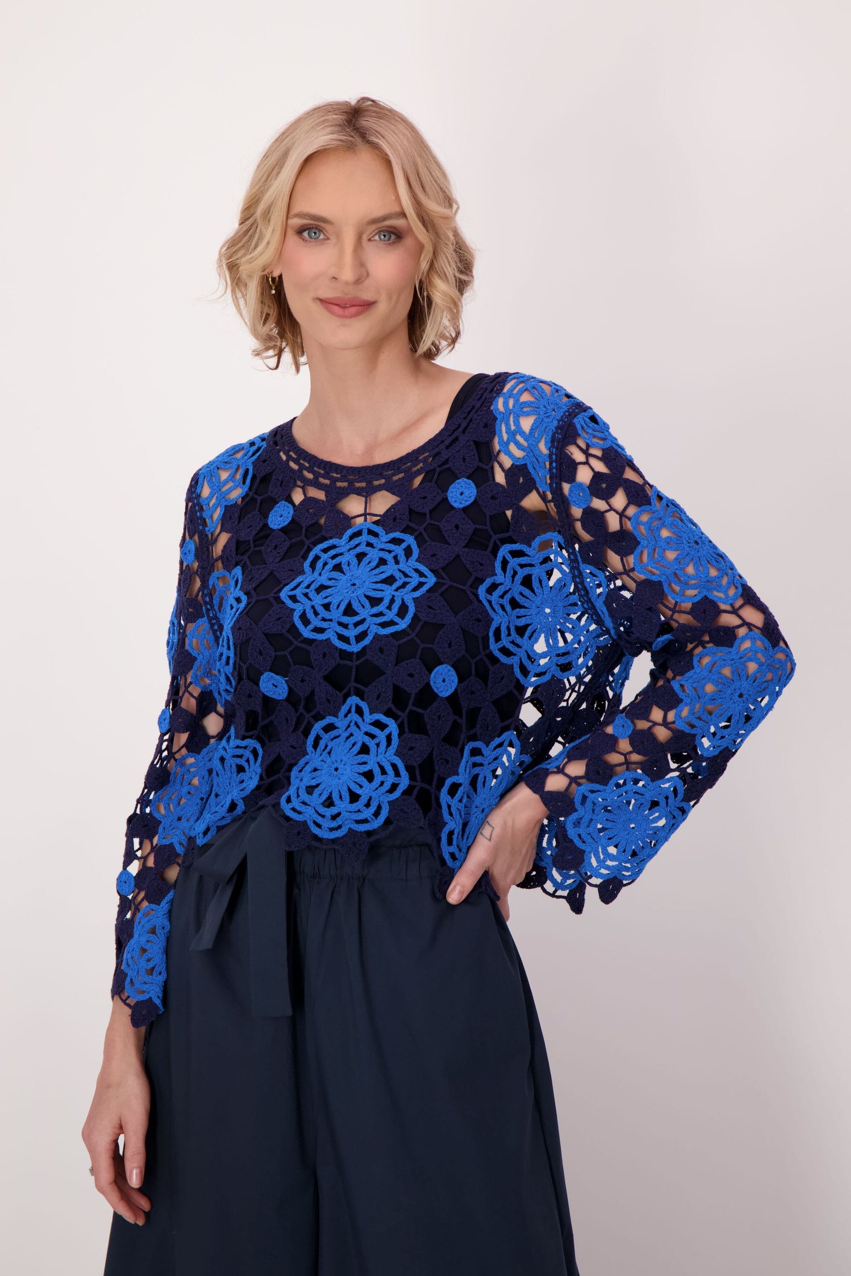 Woman wearing a blue and black floral patterned top on a white background