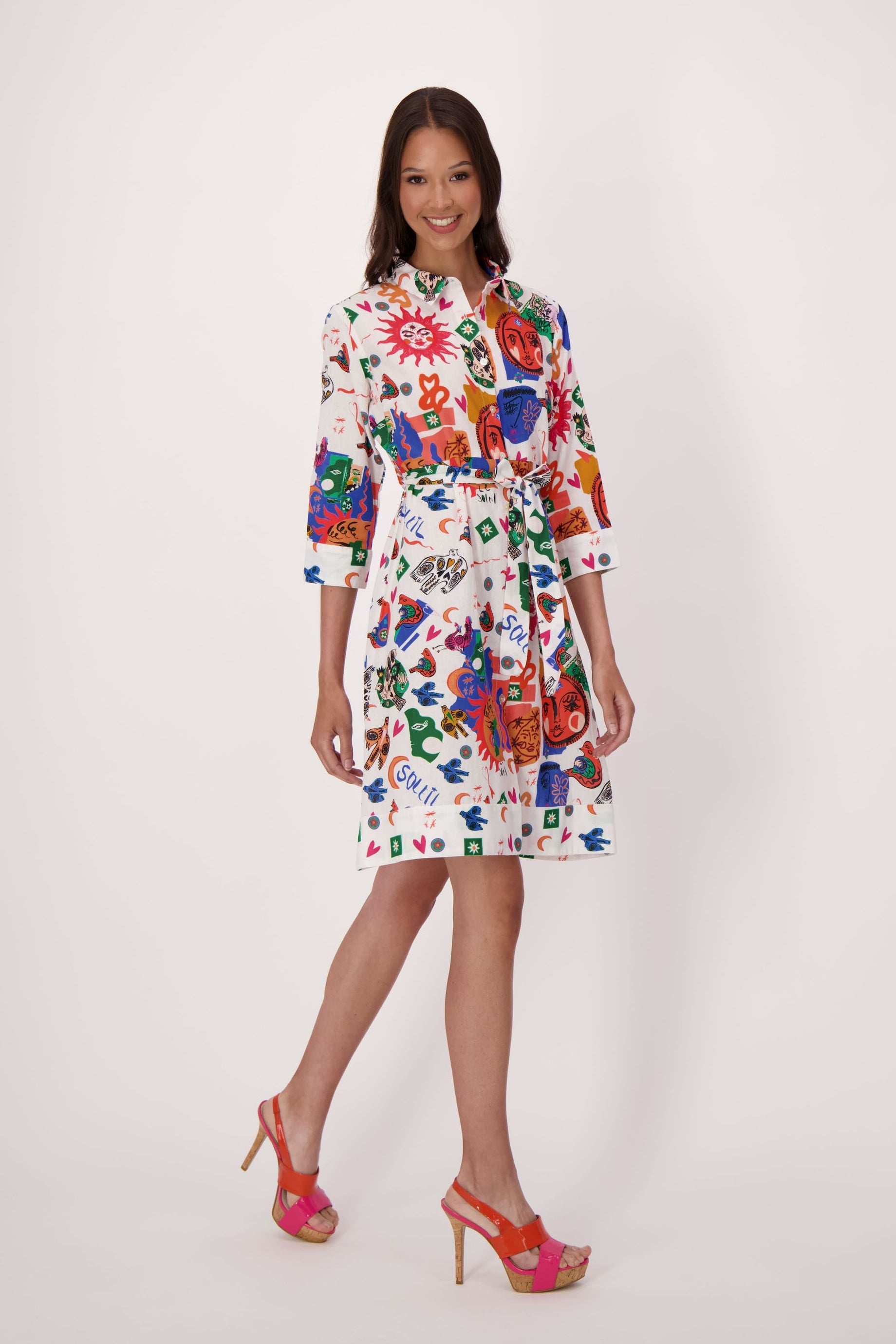 Woman wearing a colorful sun and moon abstract print dress on a white background