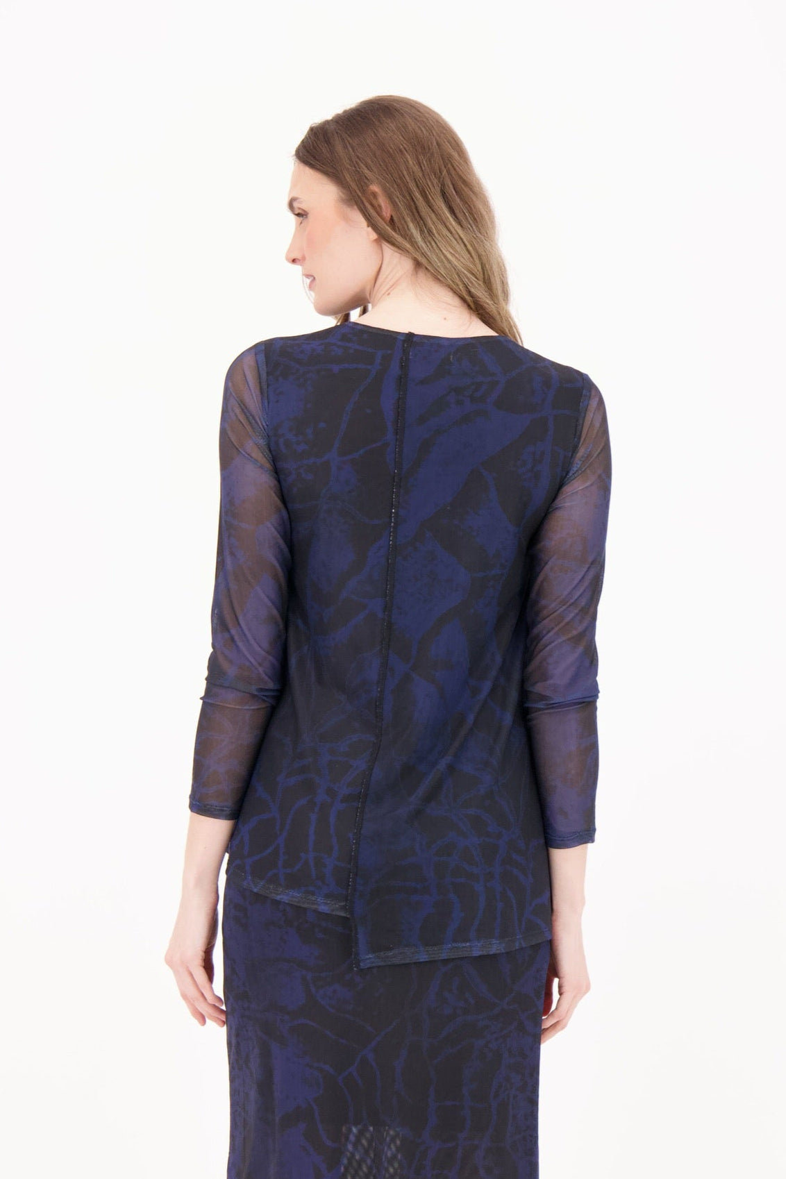Woman wearing a dark blue patterned dress on a white background