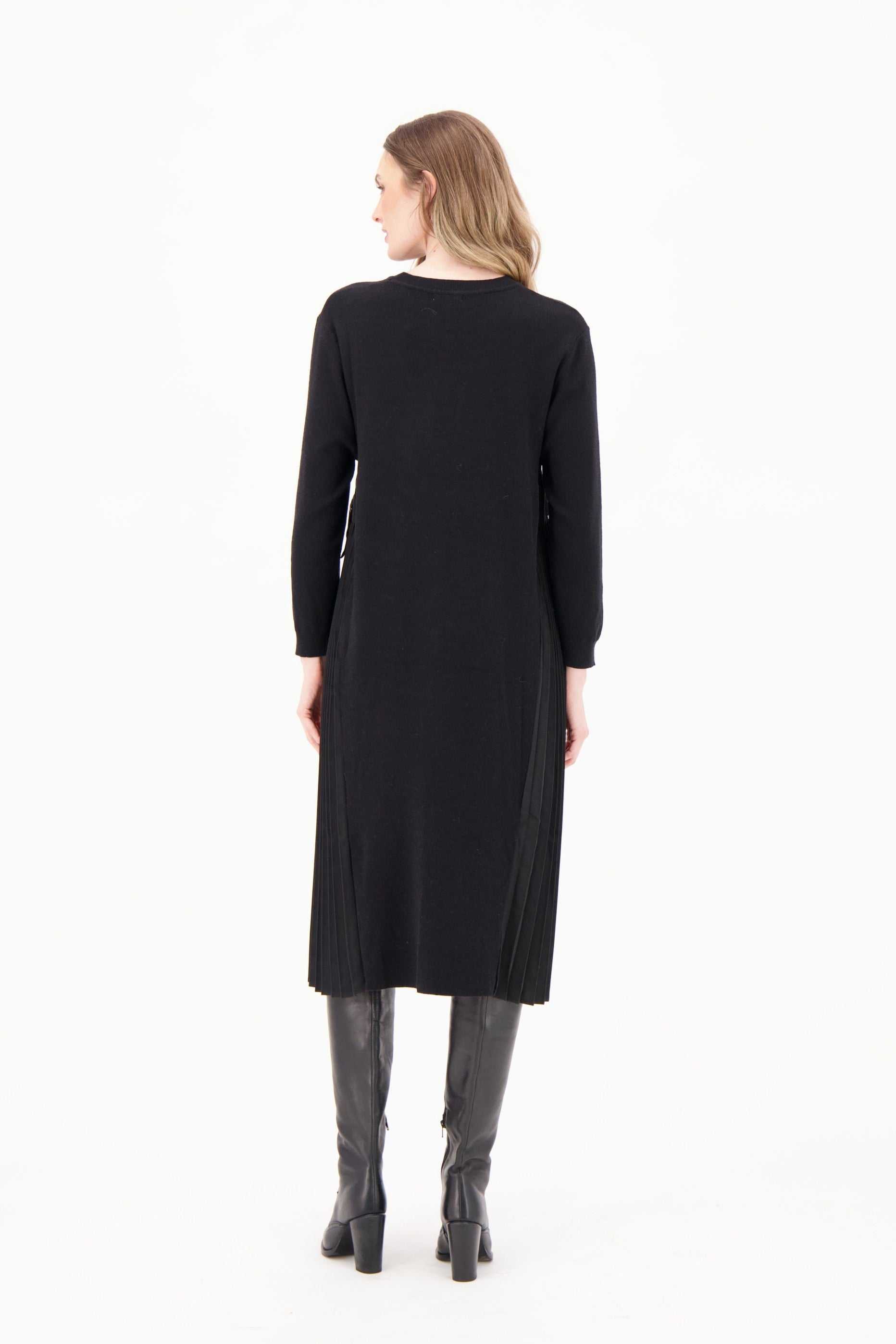 Woman wearing a black dress with long sleeves on a white background