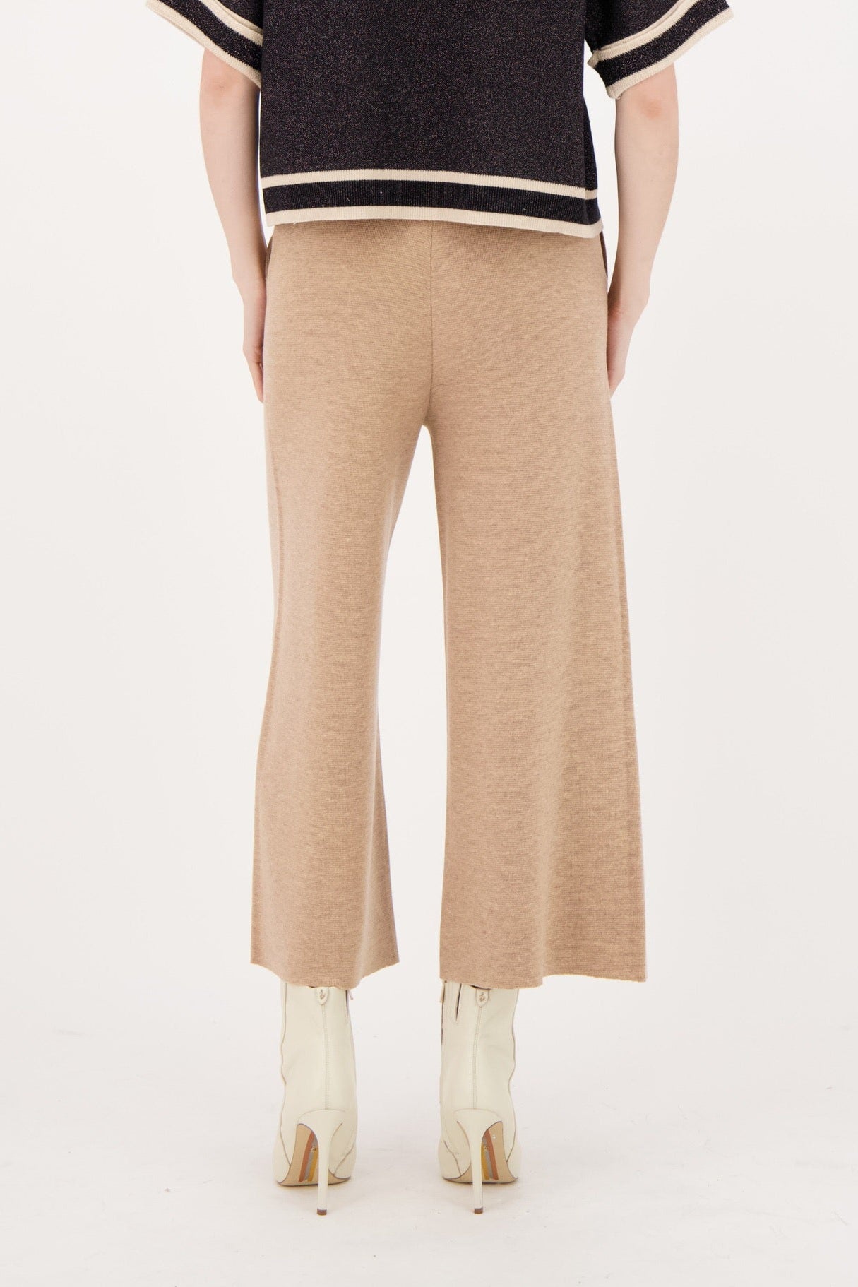 Woman wearing a black and beige outfit on a white background