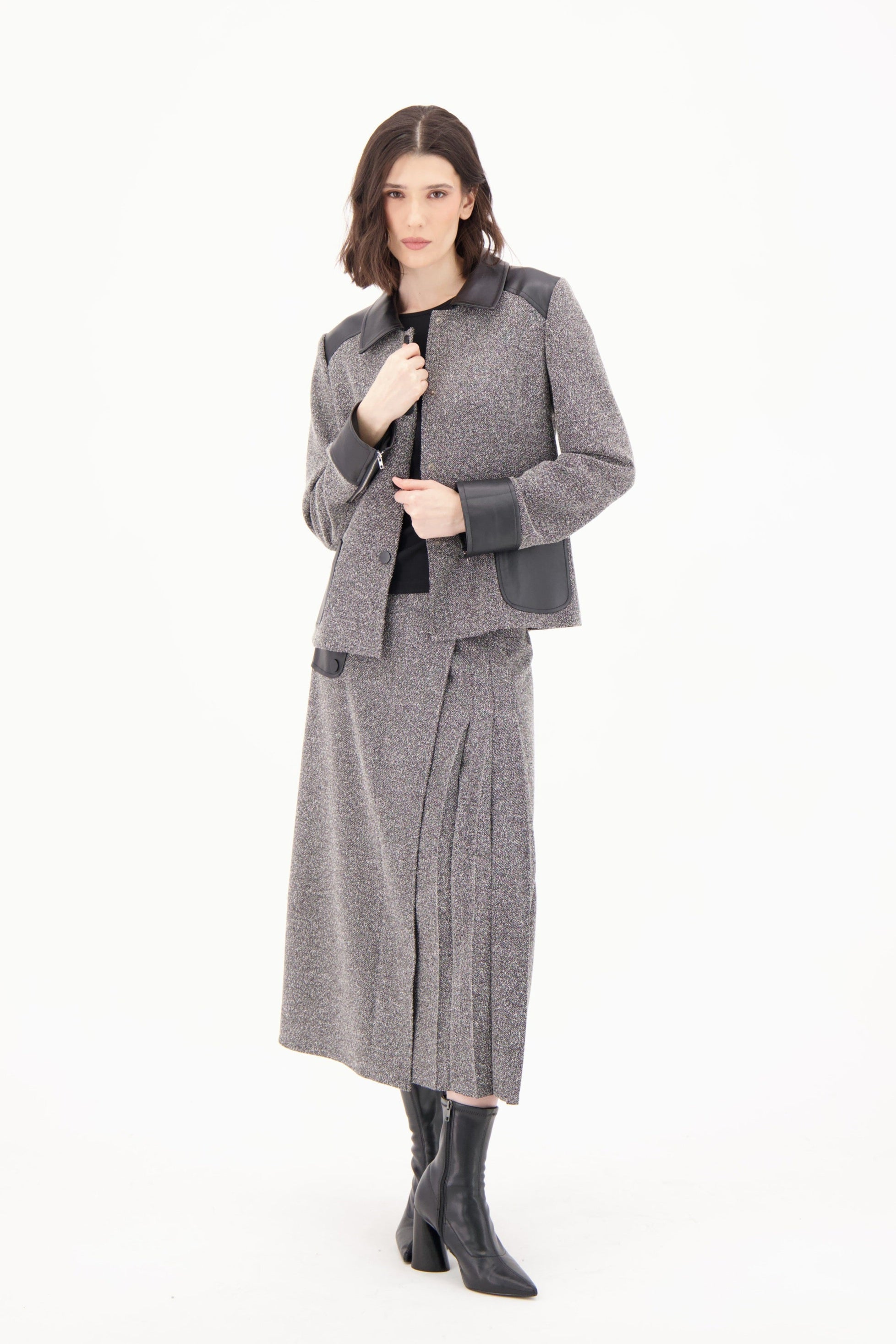 Woman wearing a gray coat and skirt set on a white background