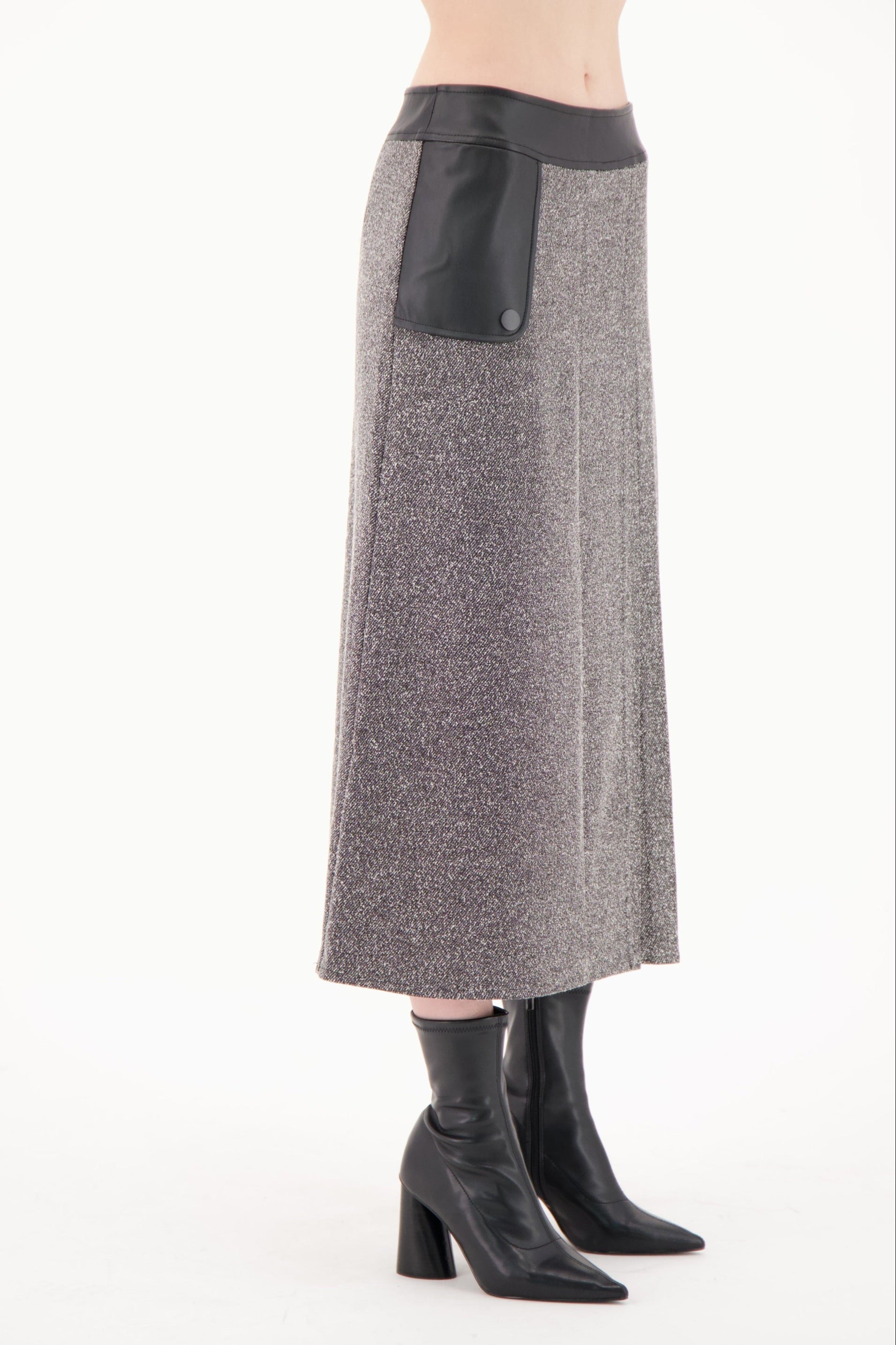 Gray skirt with black leather patch worn by a person on a white background