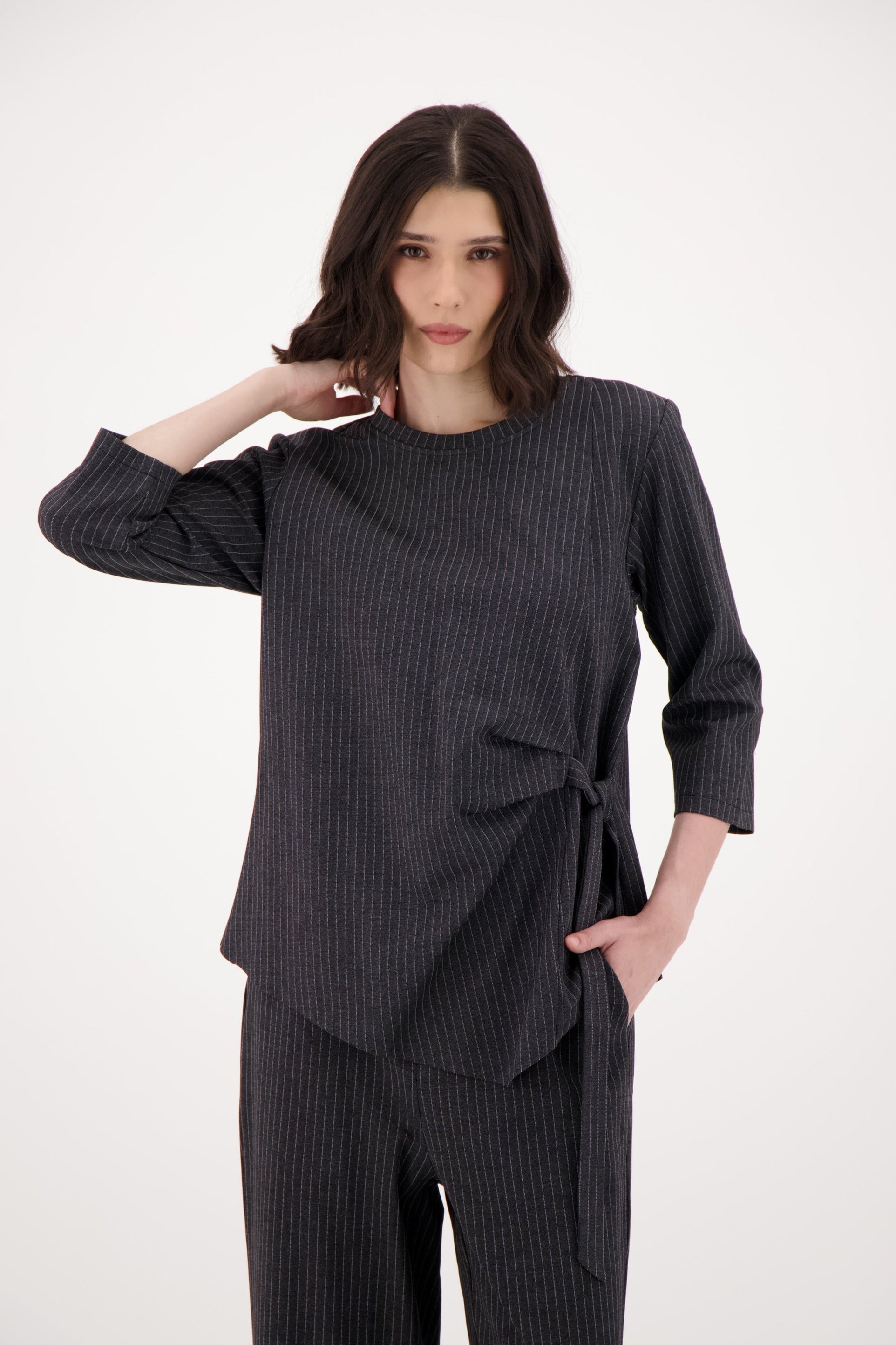 Woman wearing a dark gray ribbed outfit on a white background