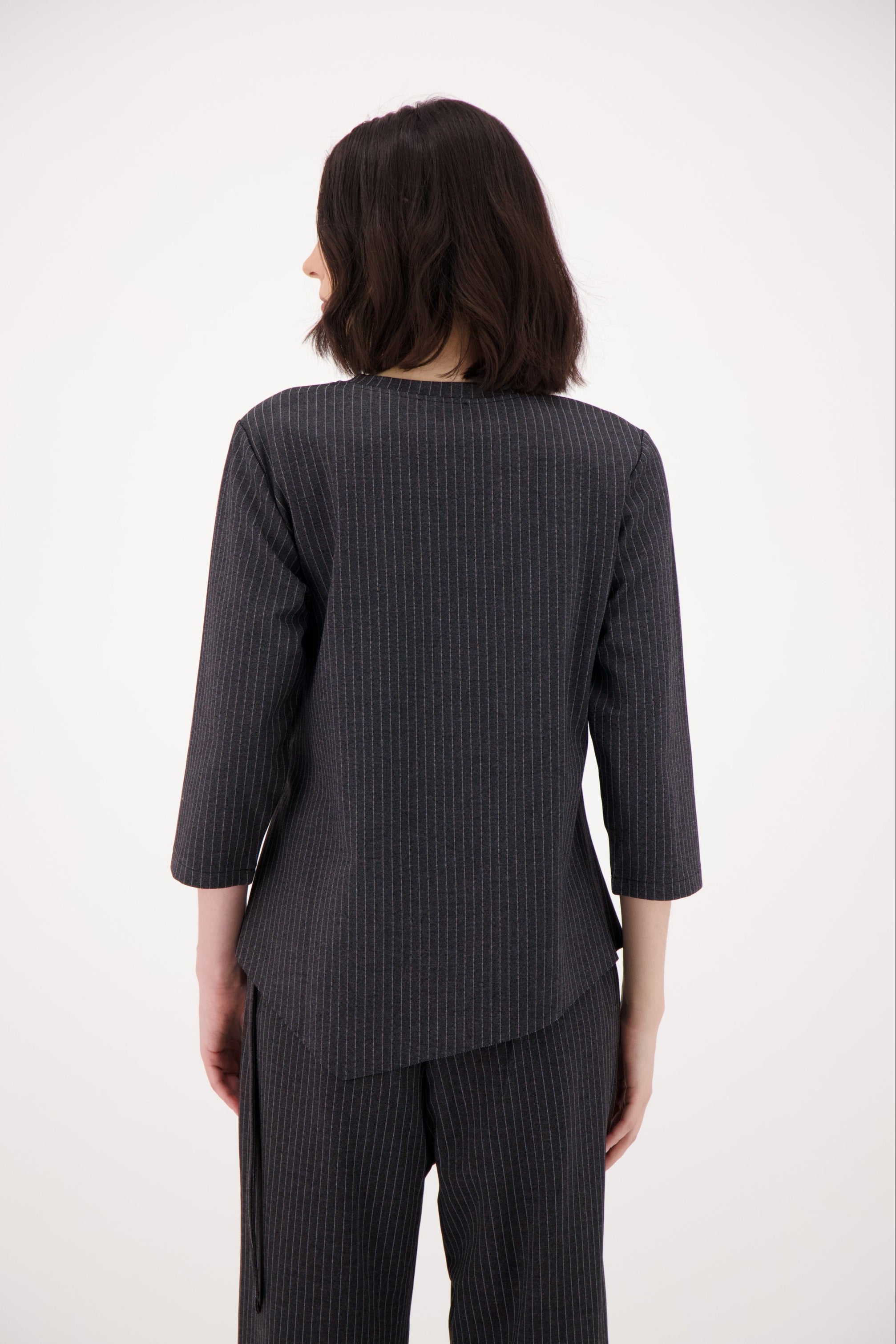 Person wearing a gray pinstripe suit on a white background