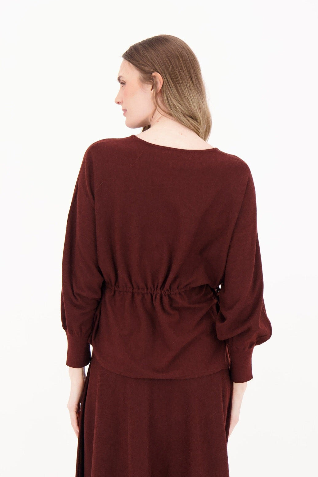 Woman wearing a burgundy dress on a white background