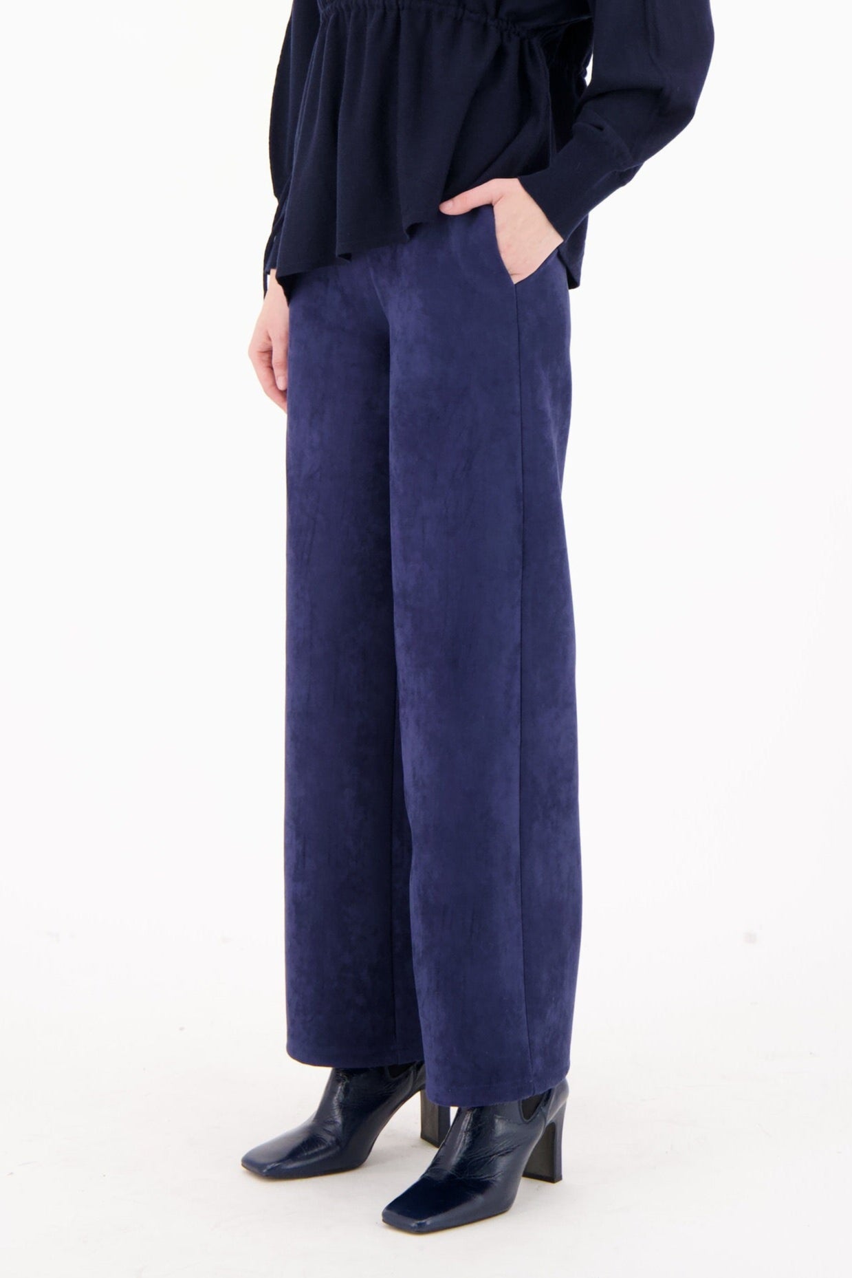 Woman wearing a navy blue outfit on a white background