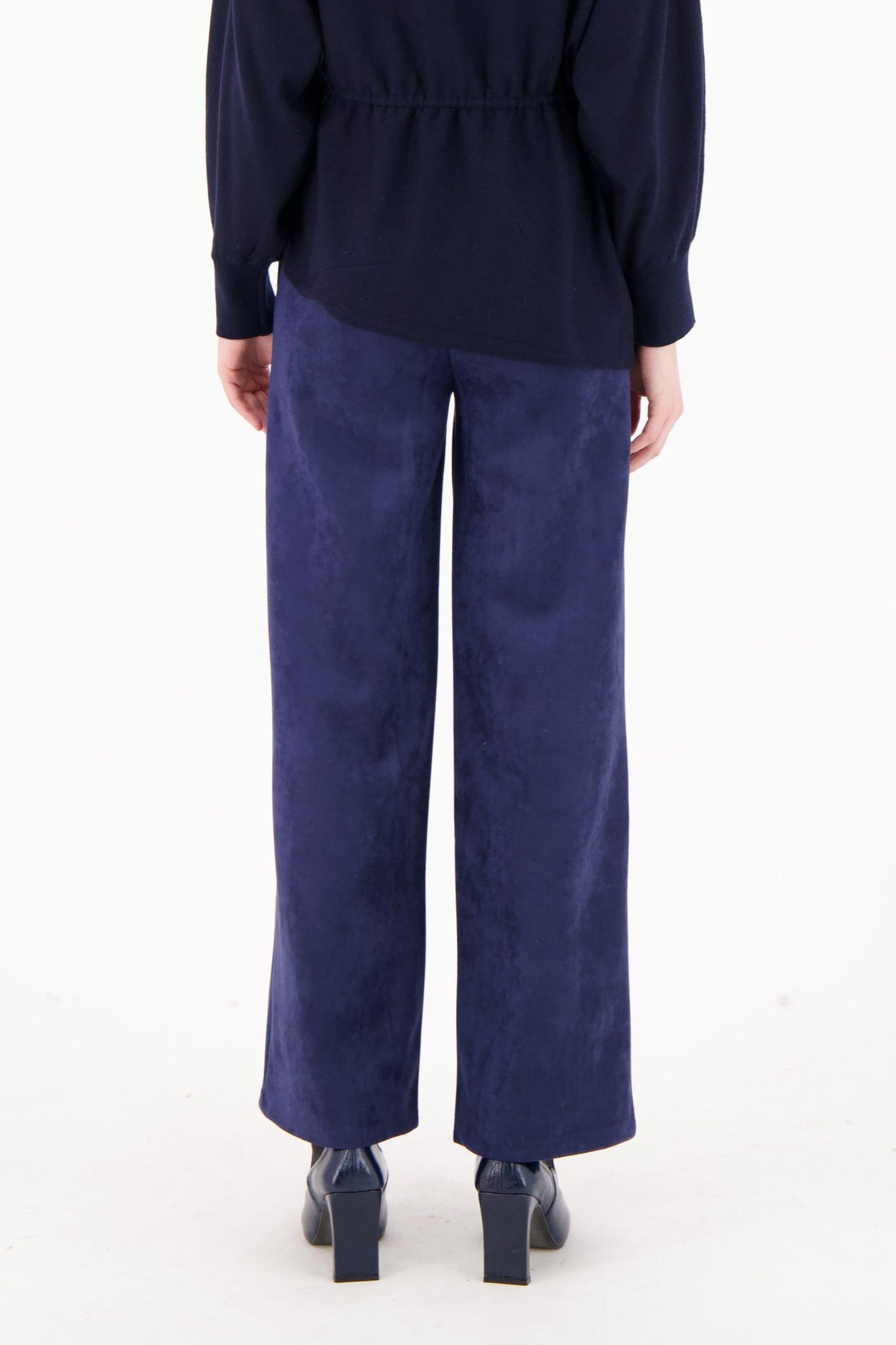 Person wearing a navy blue outfit on a white background