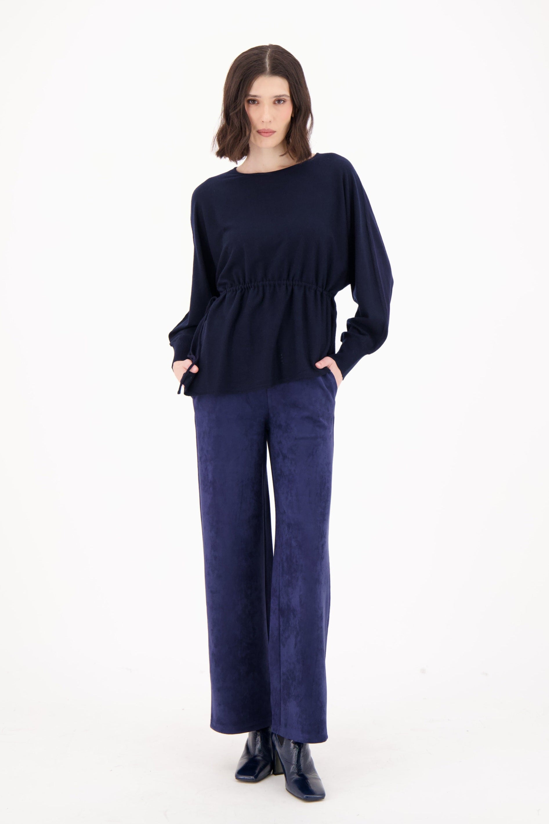 Woman wearing a navy blue outfit on a white background
