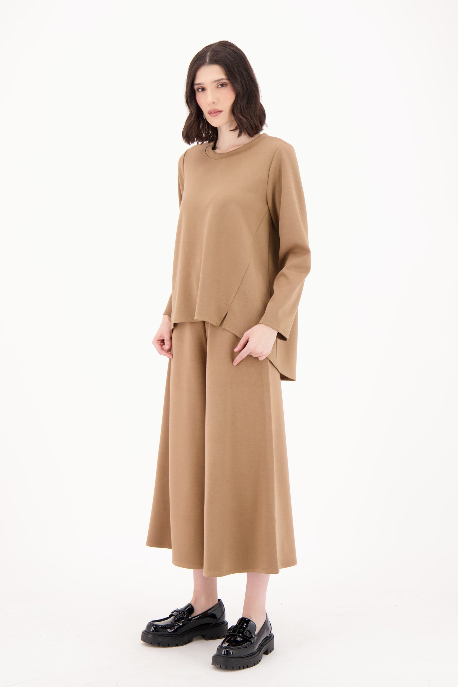 Woman wearing a beige outfit on a white background