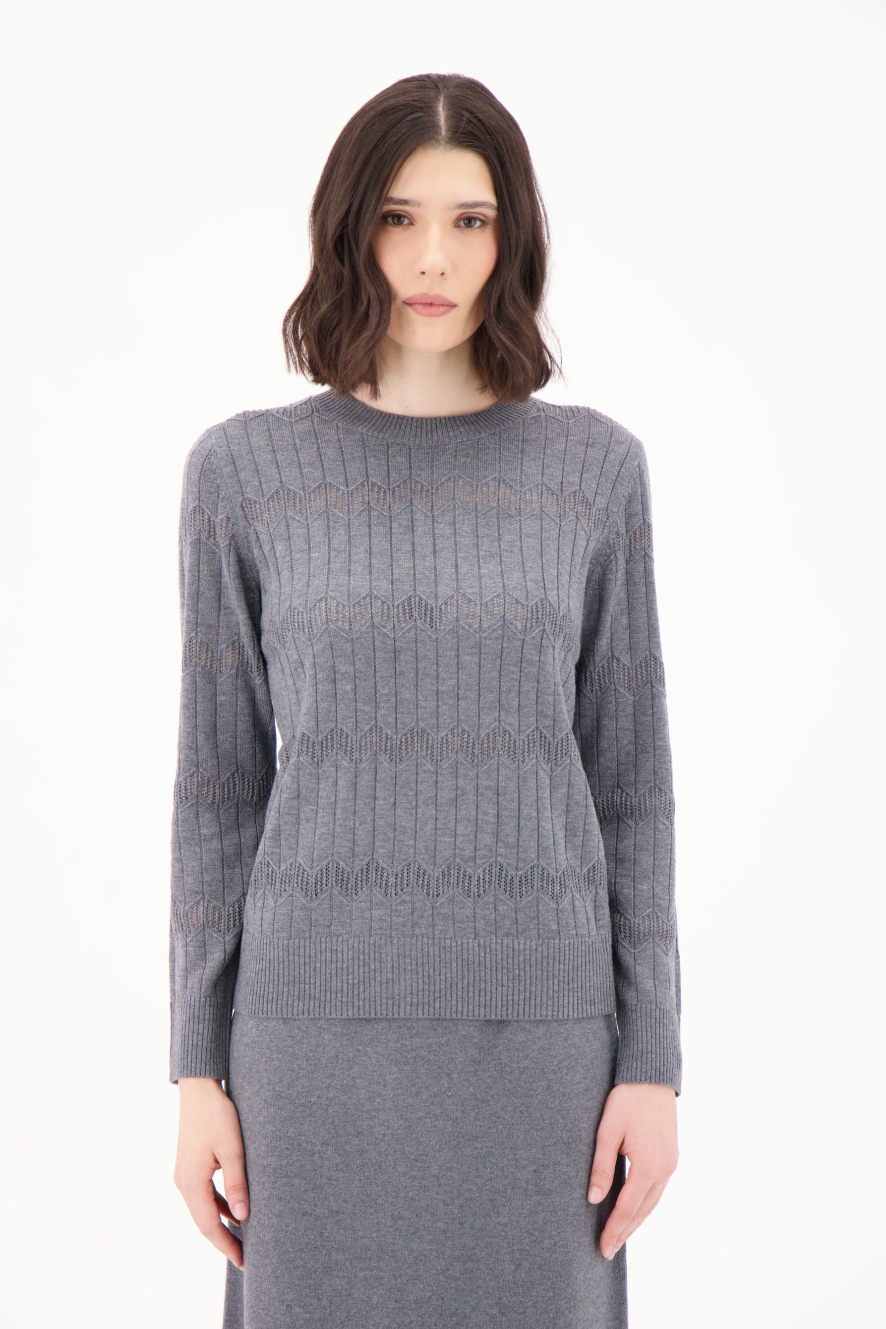 Woman wearing a gray knit outfit on a white background