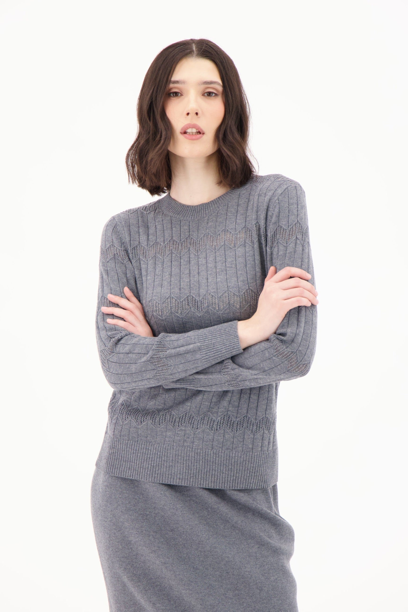 Woman wearing a gray knit outfit on a white background