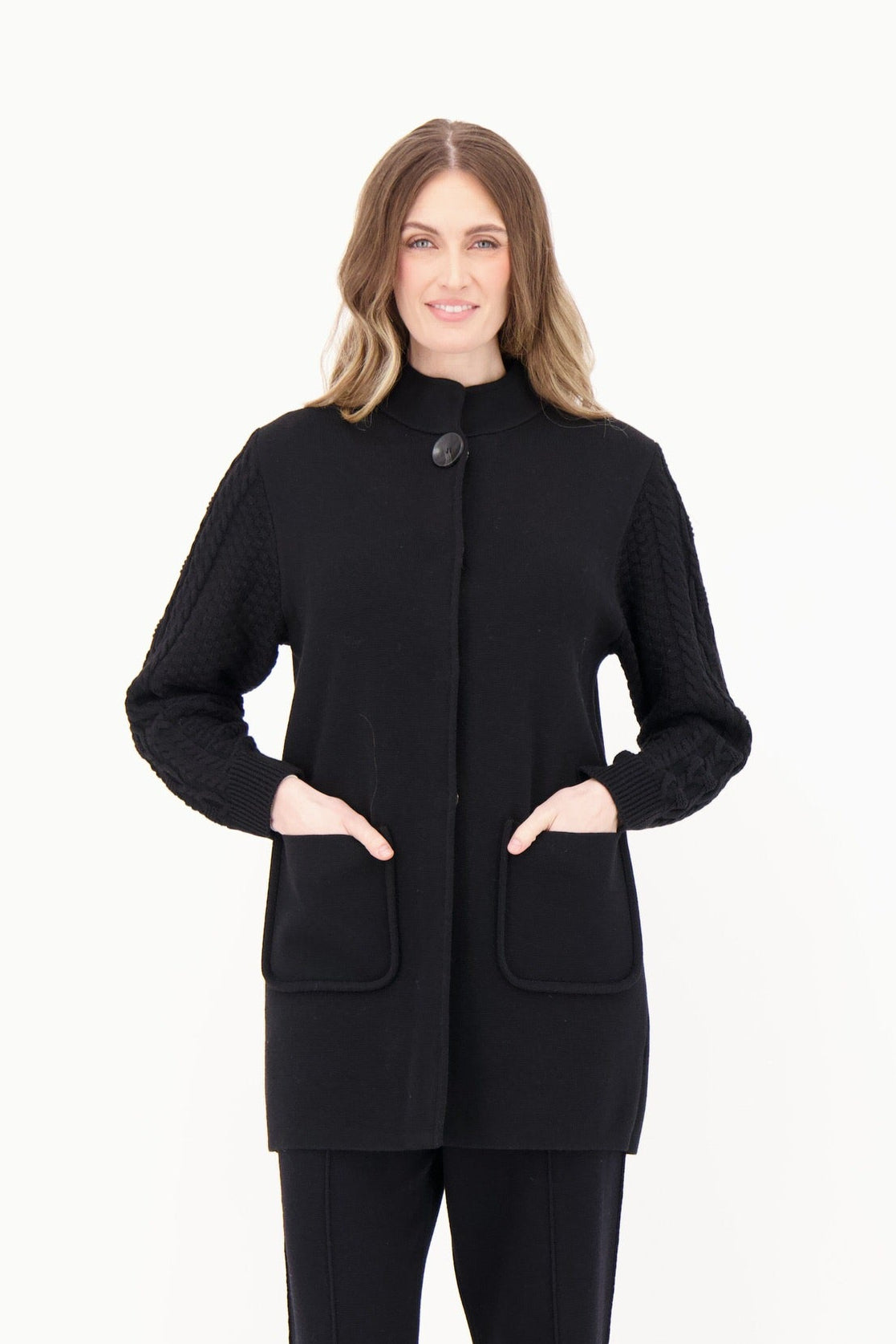 Woman wearing a black coat and pants on a white background