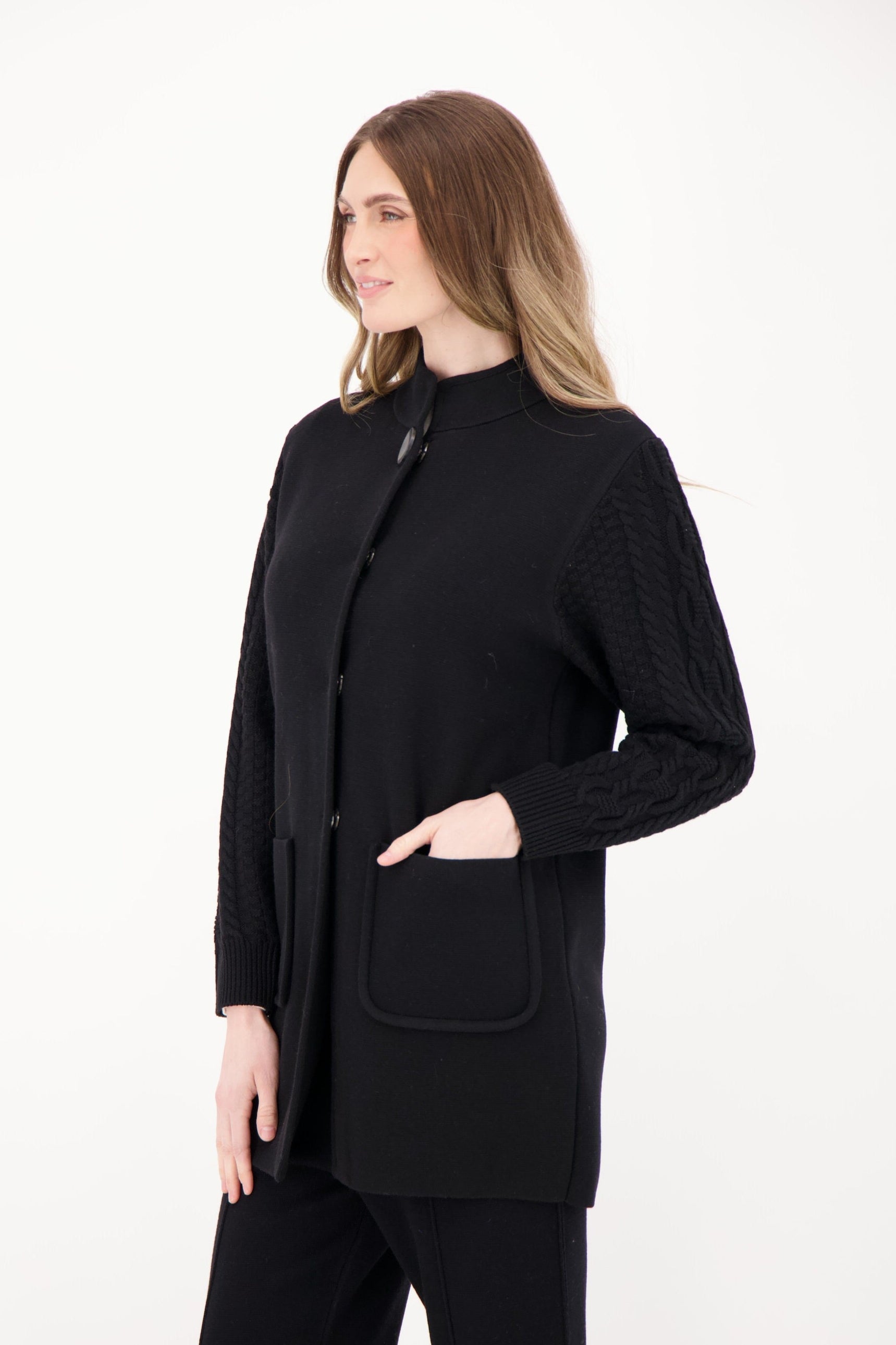 Woman wearing a black outfit with a jacket and pants on a white background