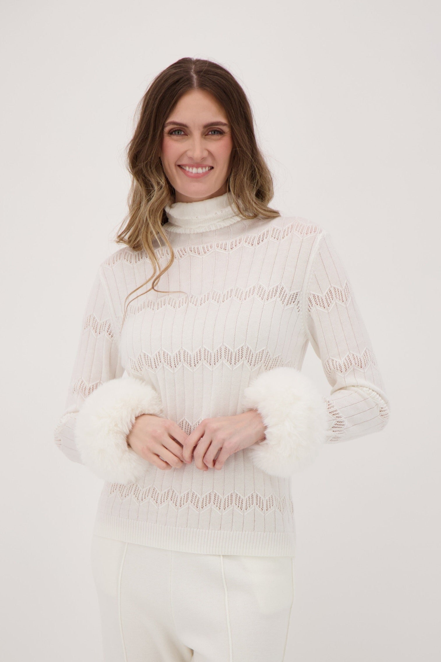 Woman wearing a white lace outfit against a plain background