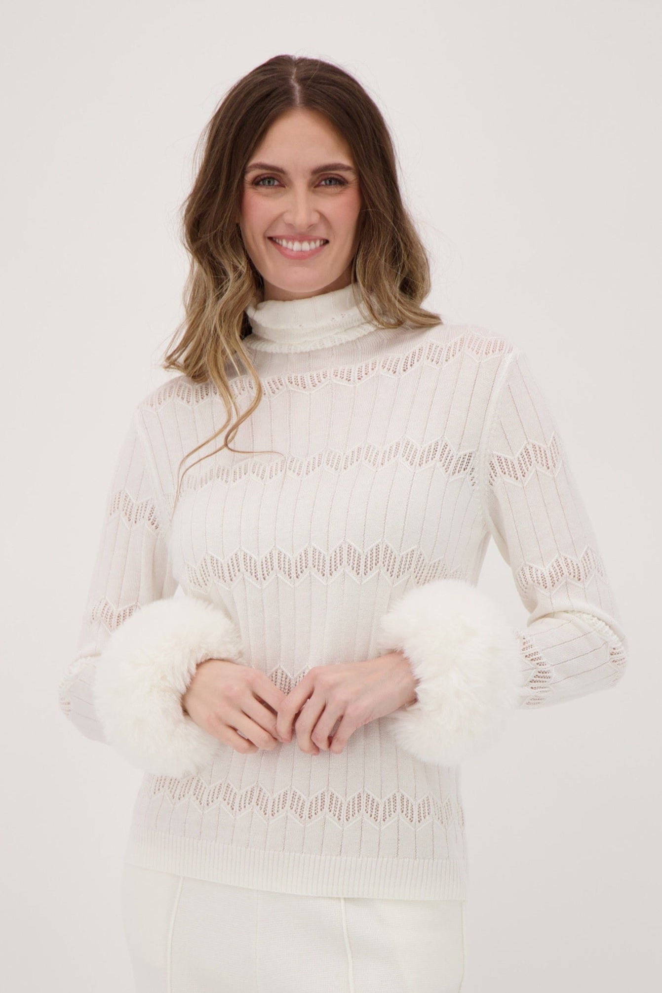 Woman wearing a white lace outfit against a plain background