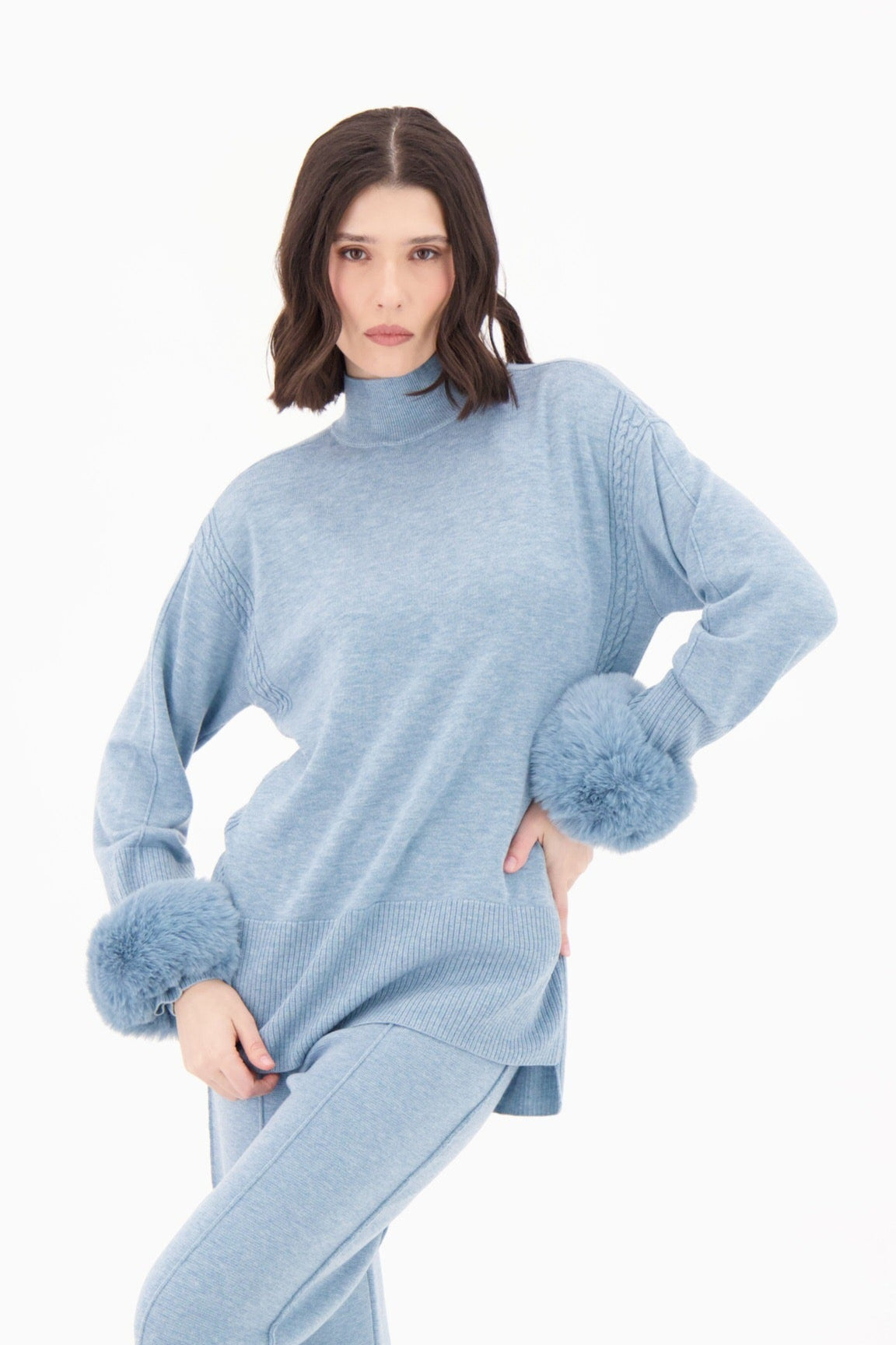 Woman wearing a light blue outfit with a matching hat on a white background