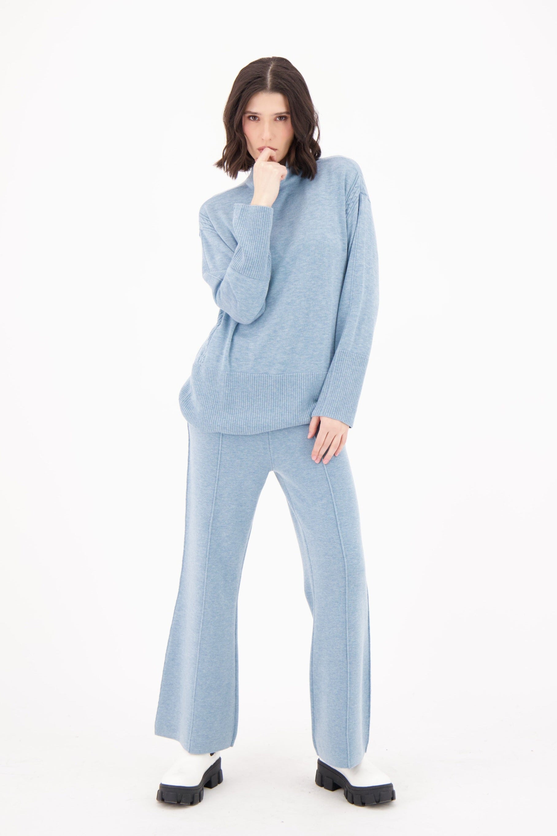 Woman wearing a light blue outfit on a white background