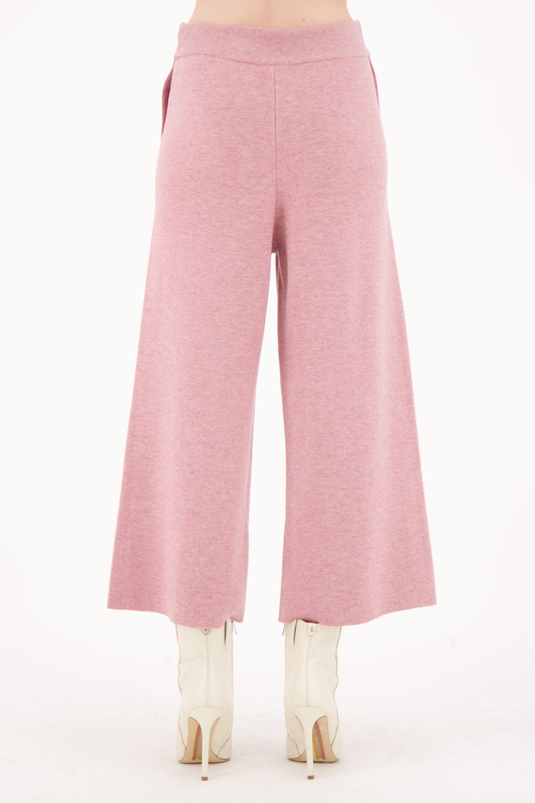 Pink wide-leg pants worn by a person on a white background