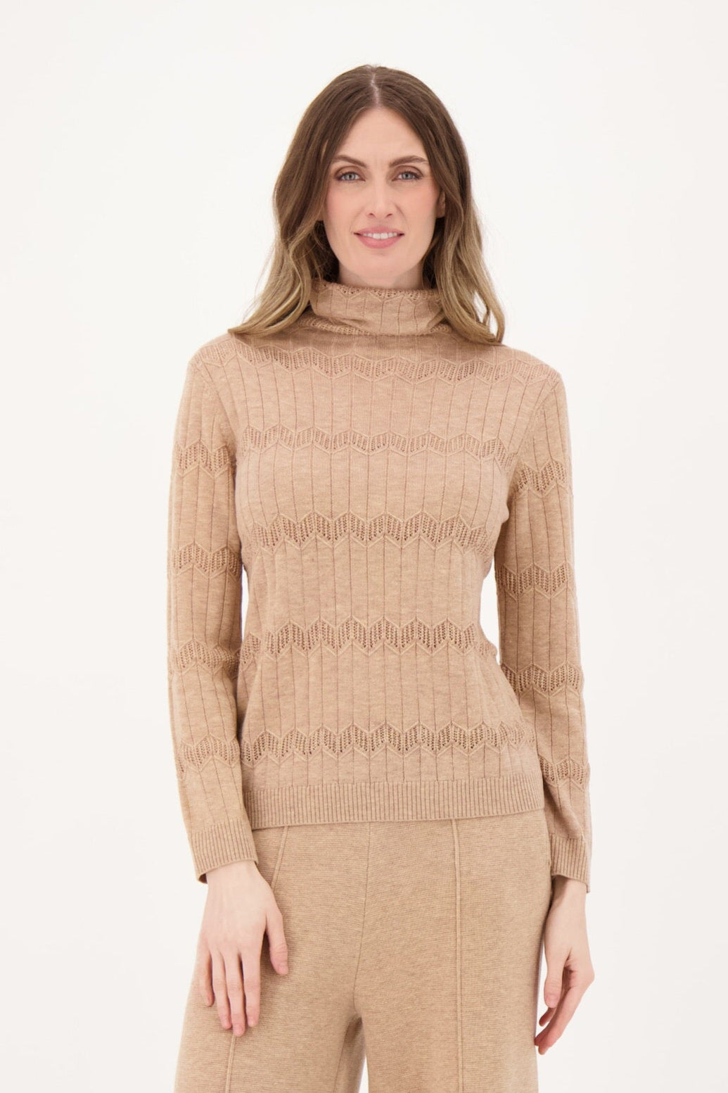 Woman wearing a beige ribbed knit outfit on a white background
