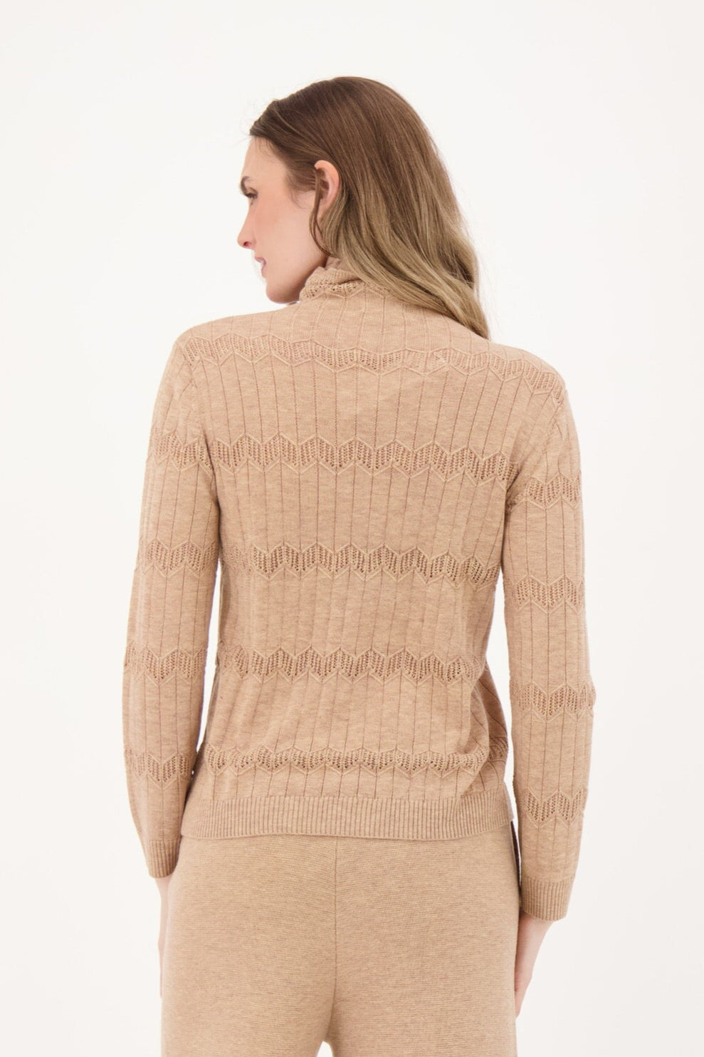Woman wearing a beige ribbed knit outfit on a white background