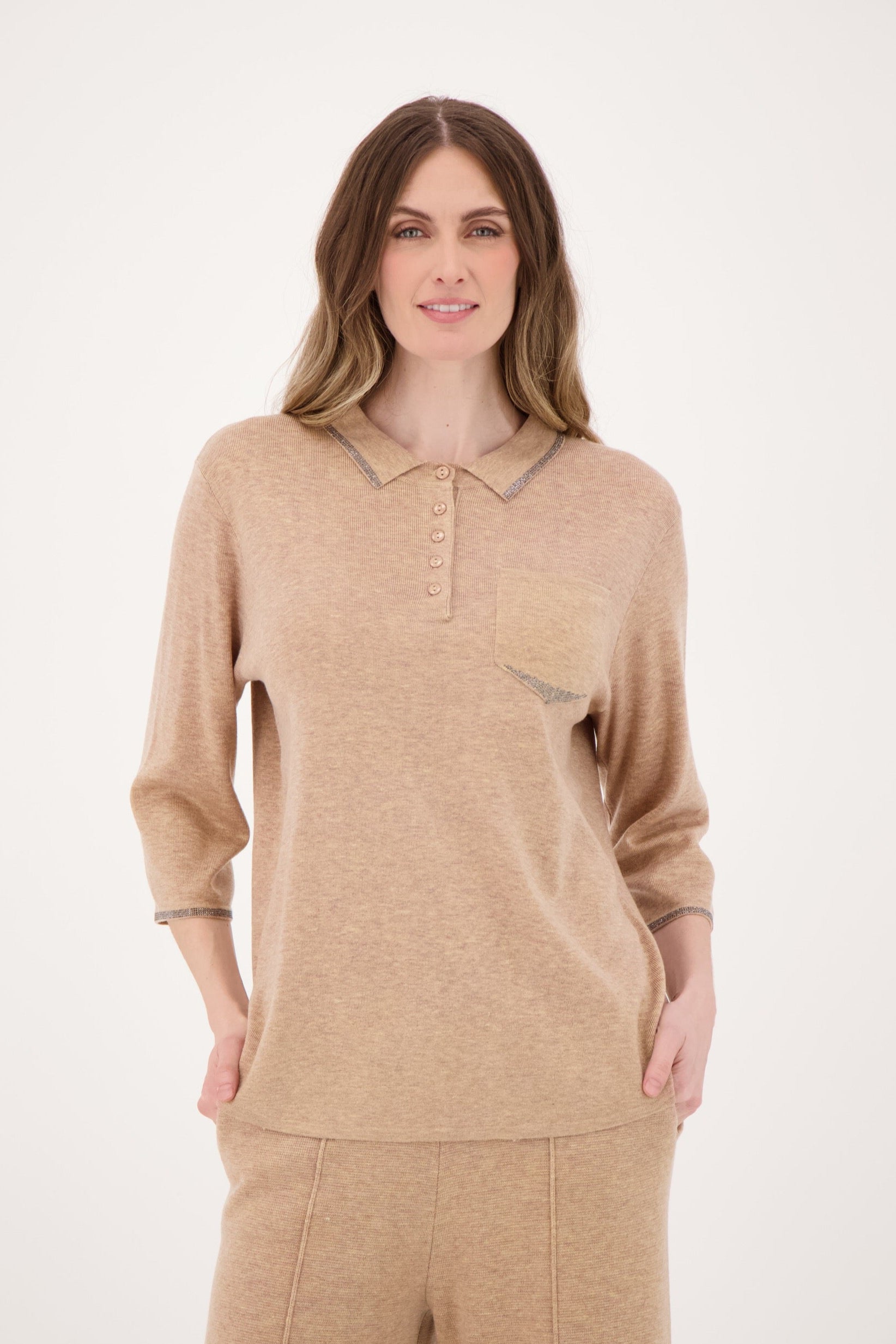 Woman wearing a beige long-sleeve top and pants on a white background