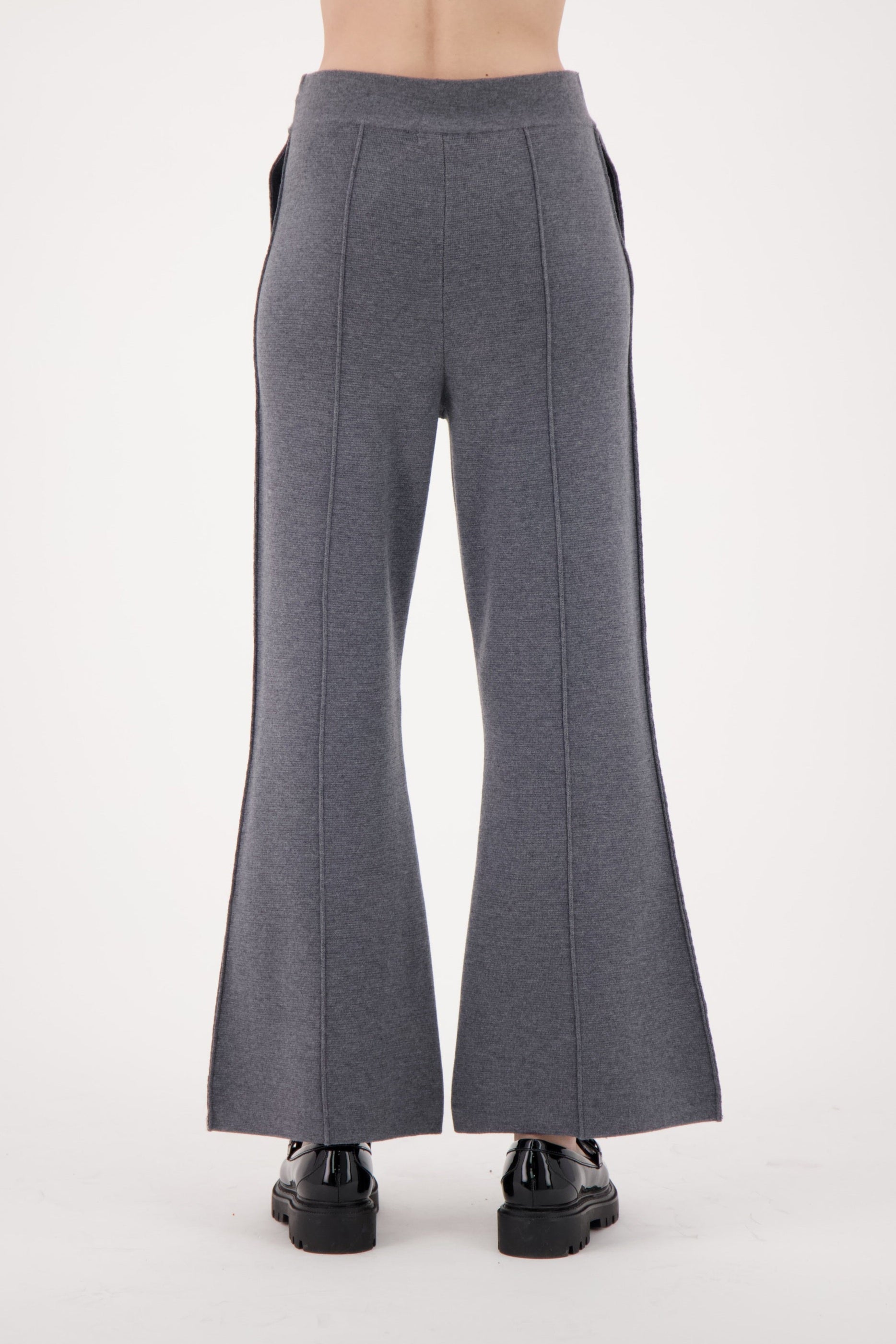 Gray flared pants worn by a person on a white background