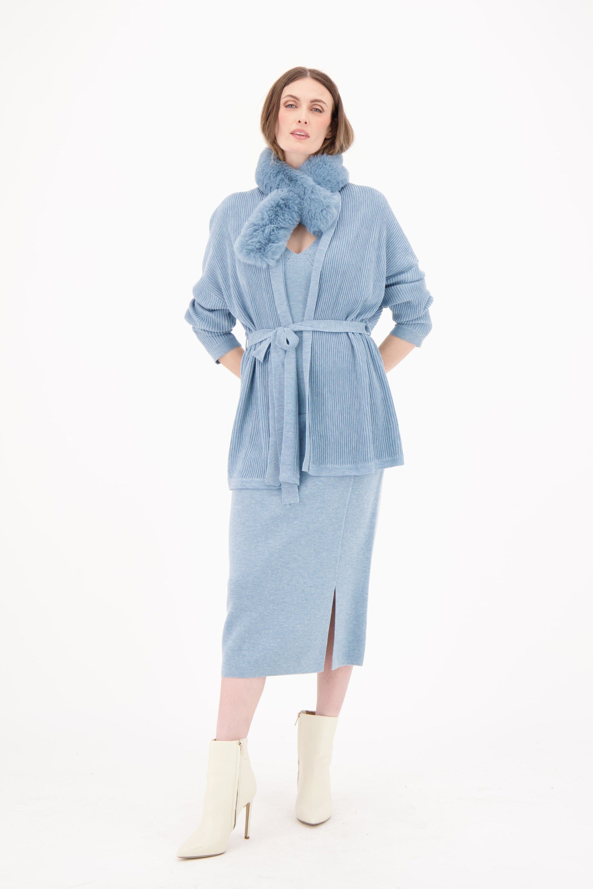 Woman wearing a light blue robe with a belt and scarf on a white background