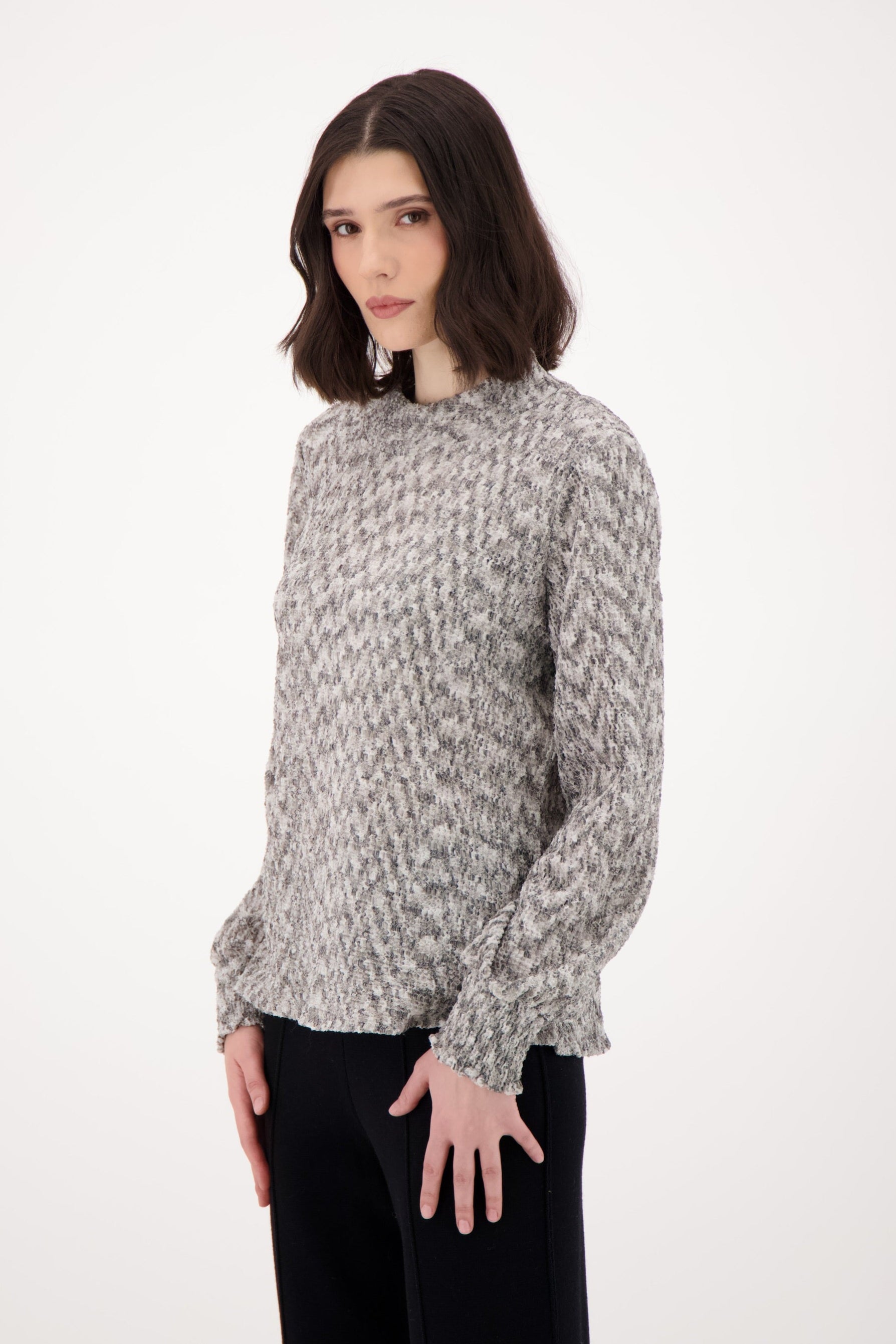 Woman wearing a patterned blouse on a white background