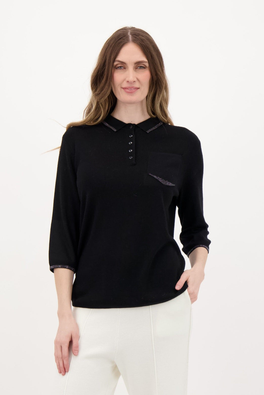 Woman wearing a black top and white pants on a white background