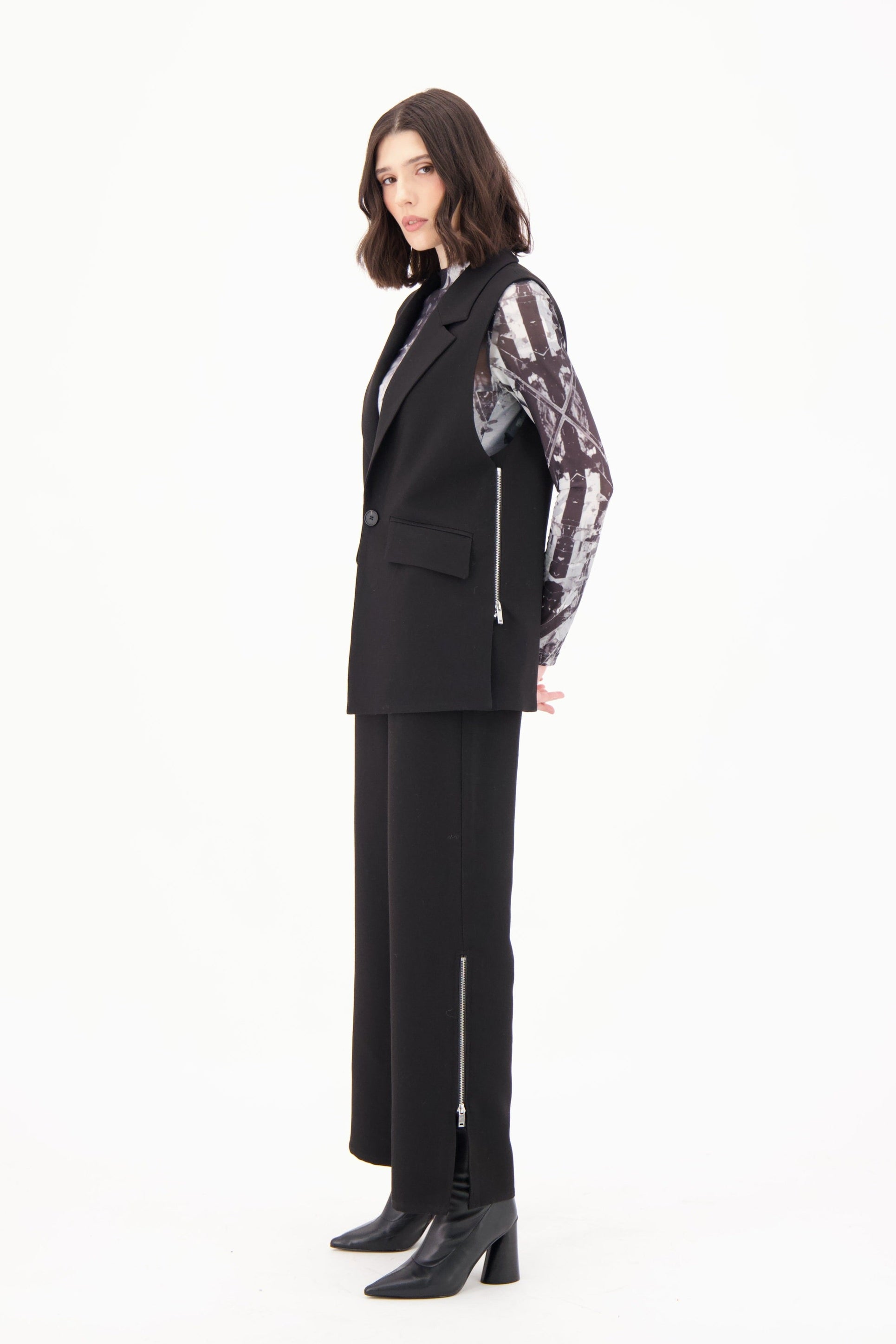 Person wearing a black suit with patterned sleeves on a white background