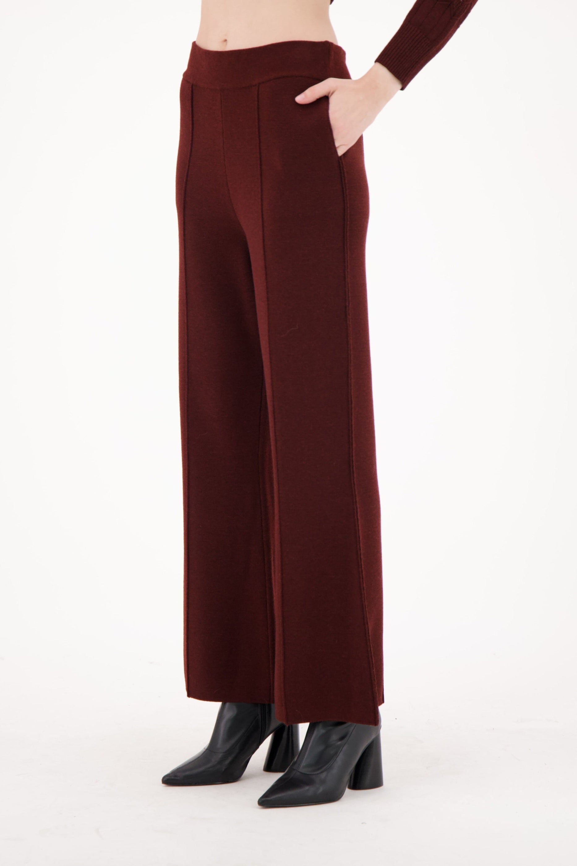 Brown wide-leg pants worn by a person on a white background
