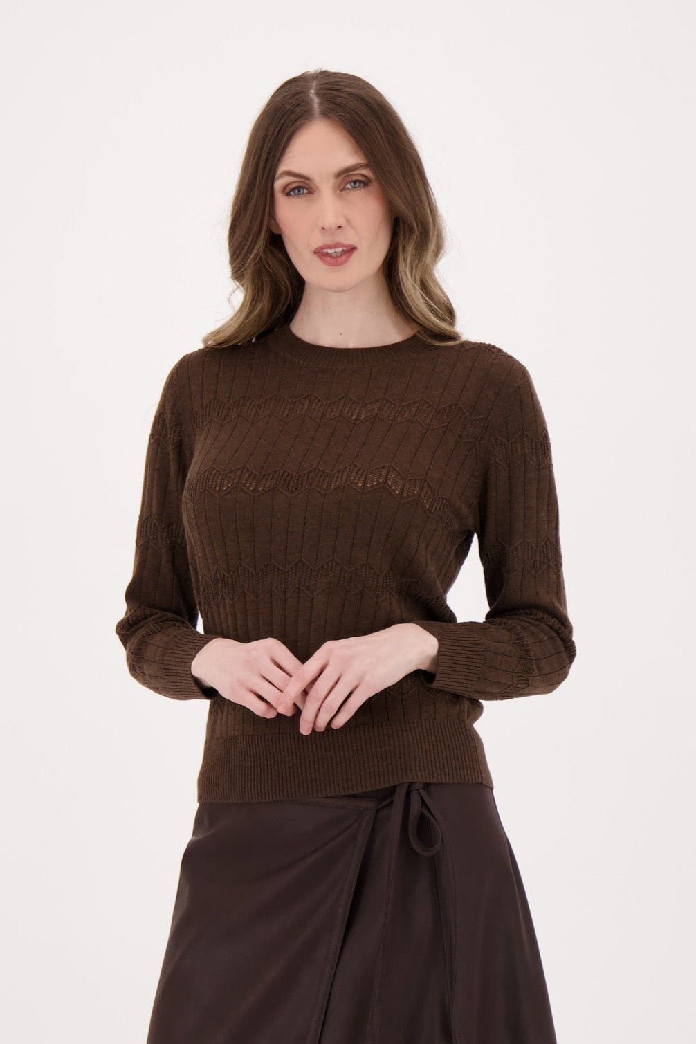 Woman wearing a brown sweater and skirt set on a white background