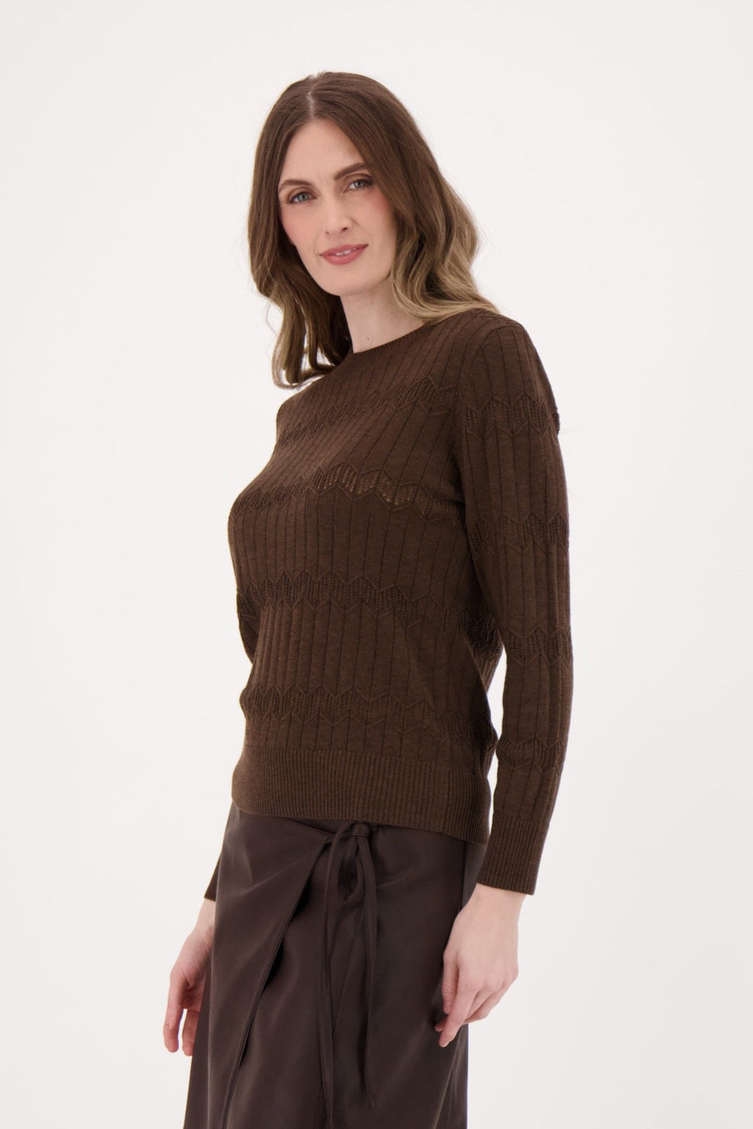 Woman wearing a brown sweater and skirt set on a white background