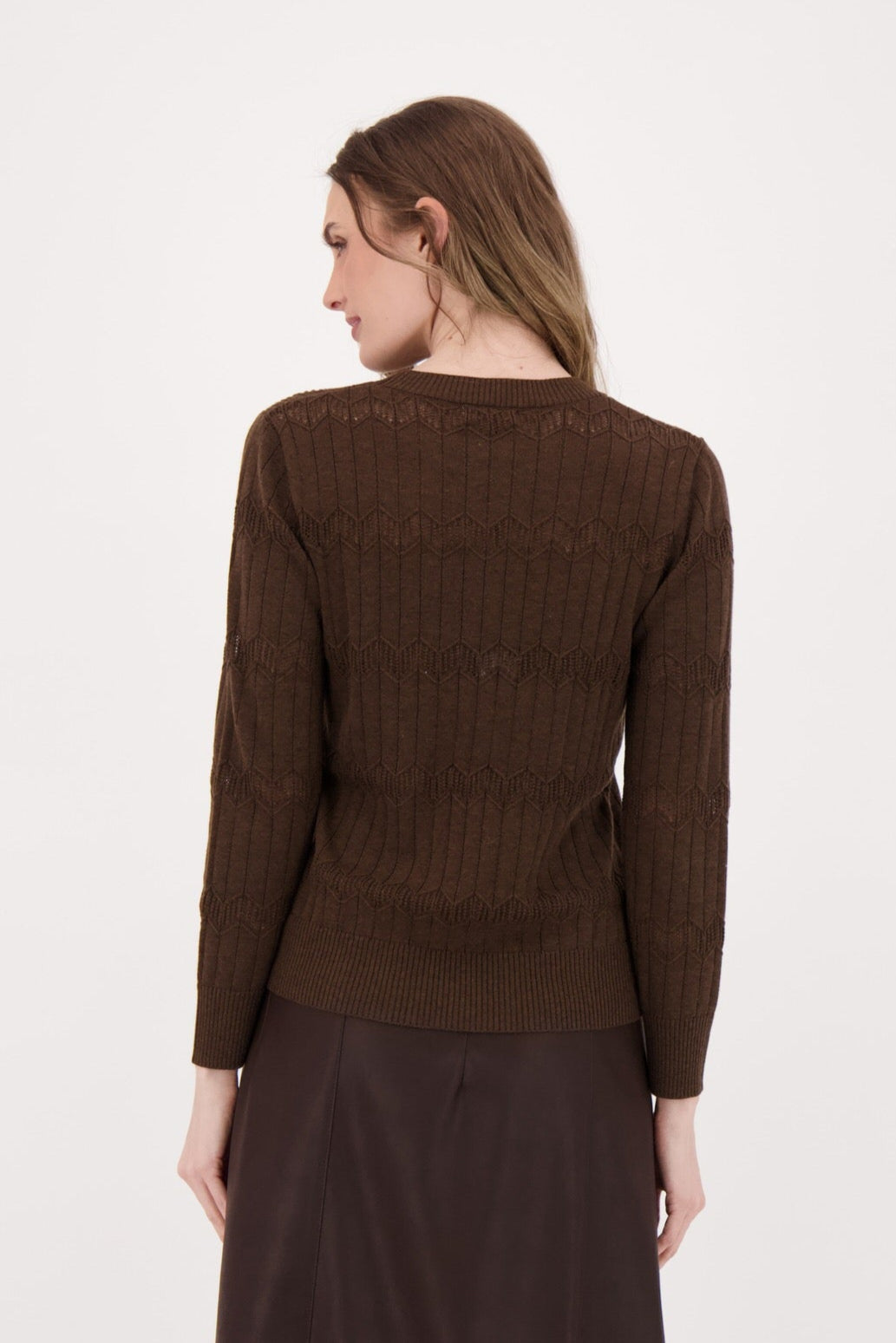 Woman wearing a brown sweater and skirt set on a white background