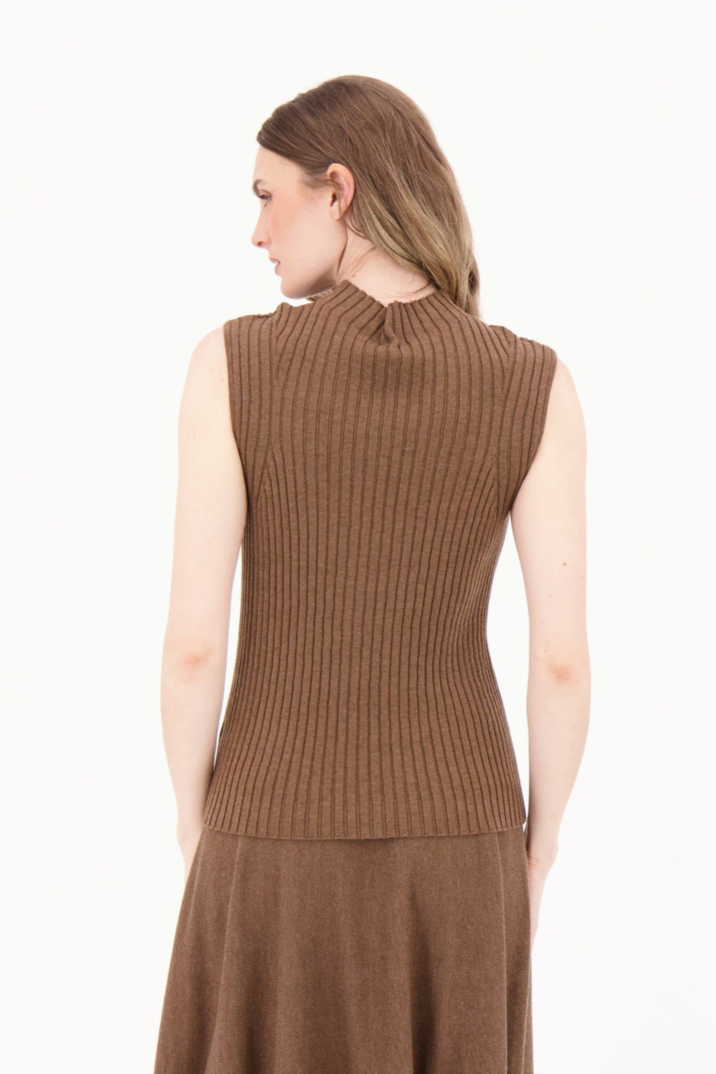 Woman wearing a brown sleeveless top and skirt set on a white background