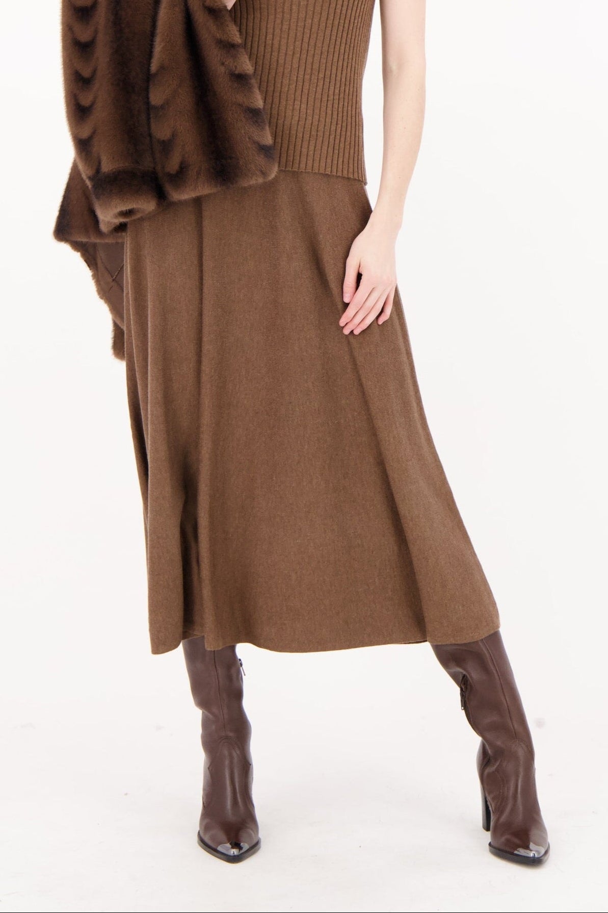 Woman wearing a brown dress with a matching jacket on a white background