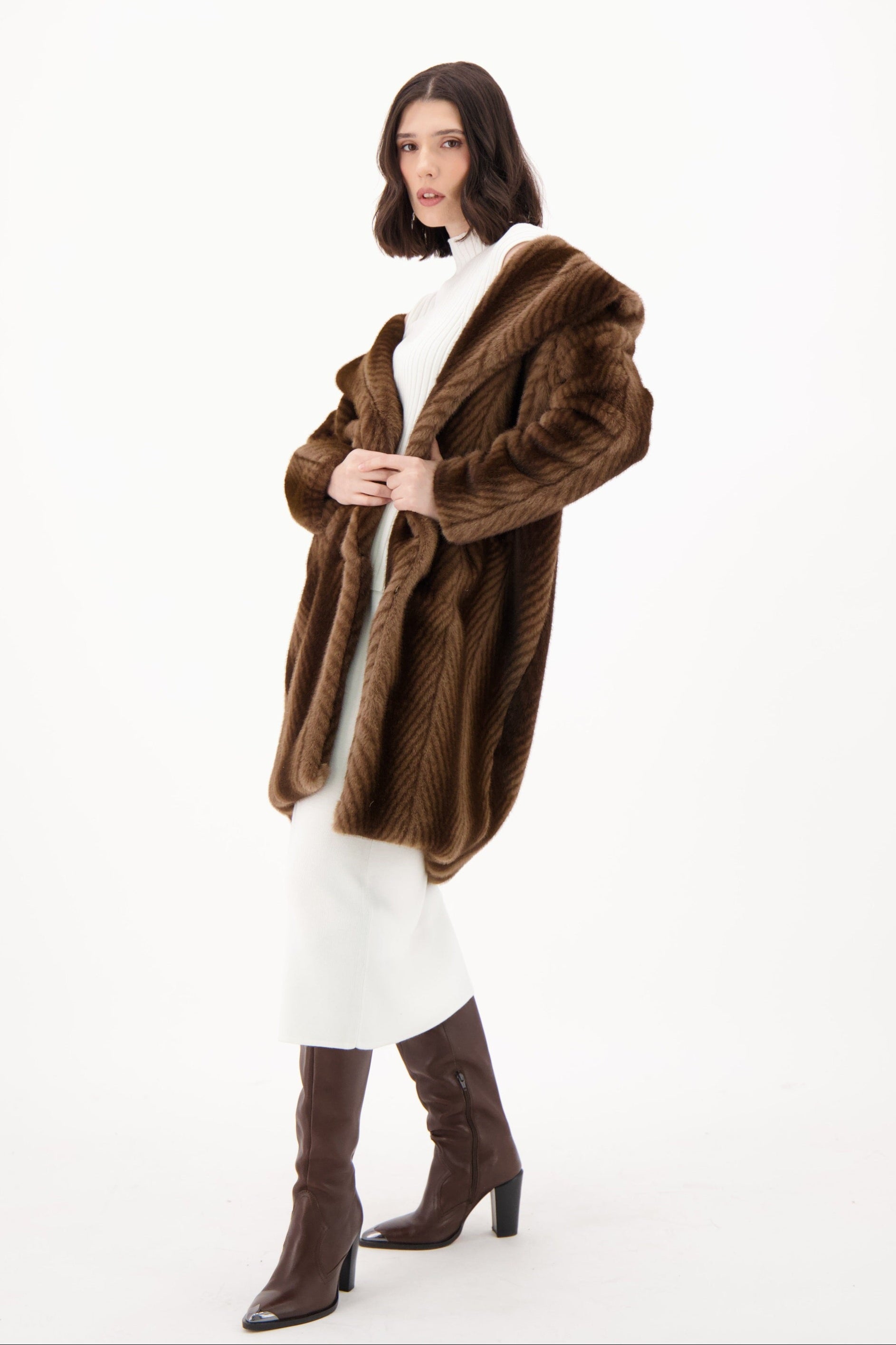 Woman wearing a brown fur coat and boots on a white background