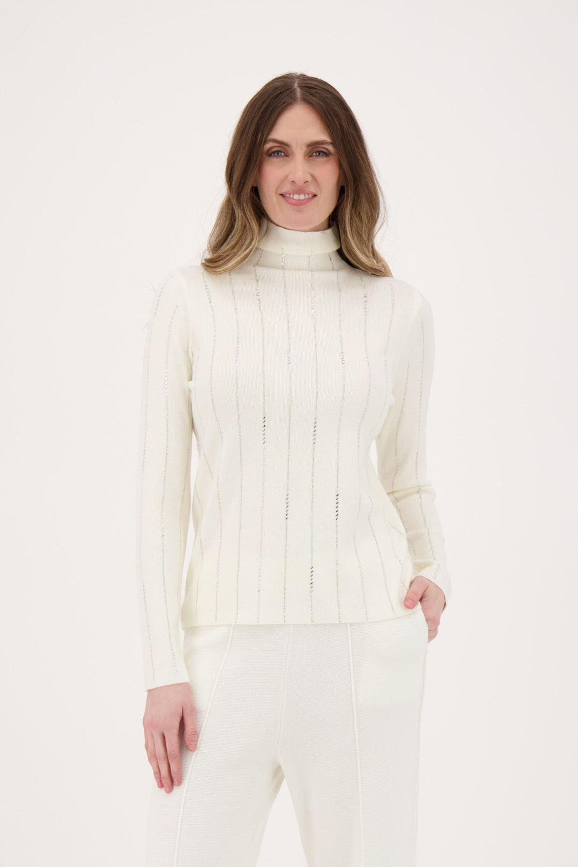 Woman wearing a white turtleneck sweater and pants on a white background