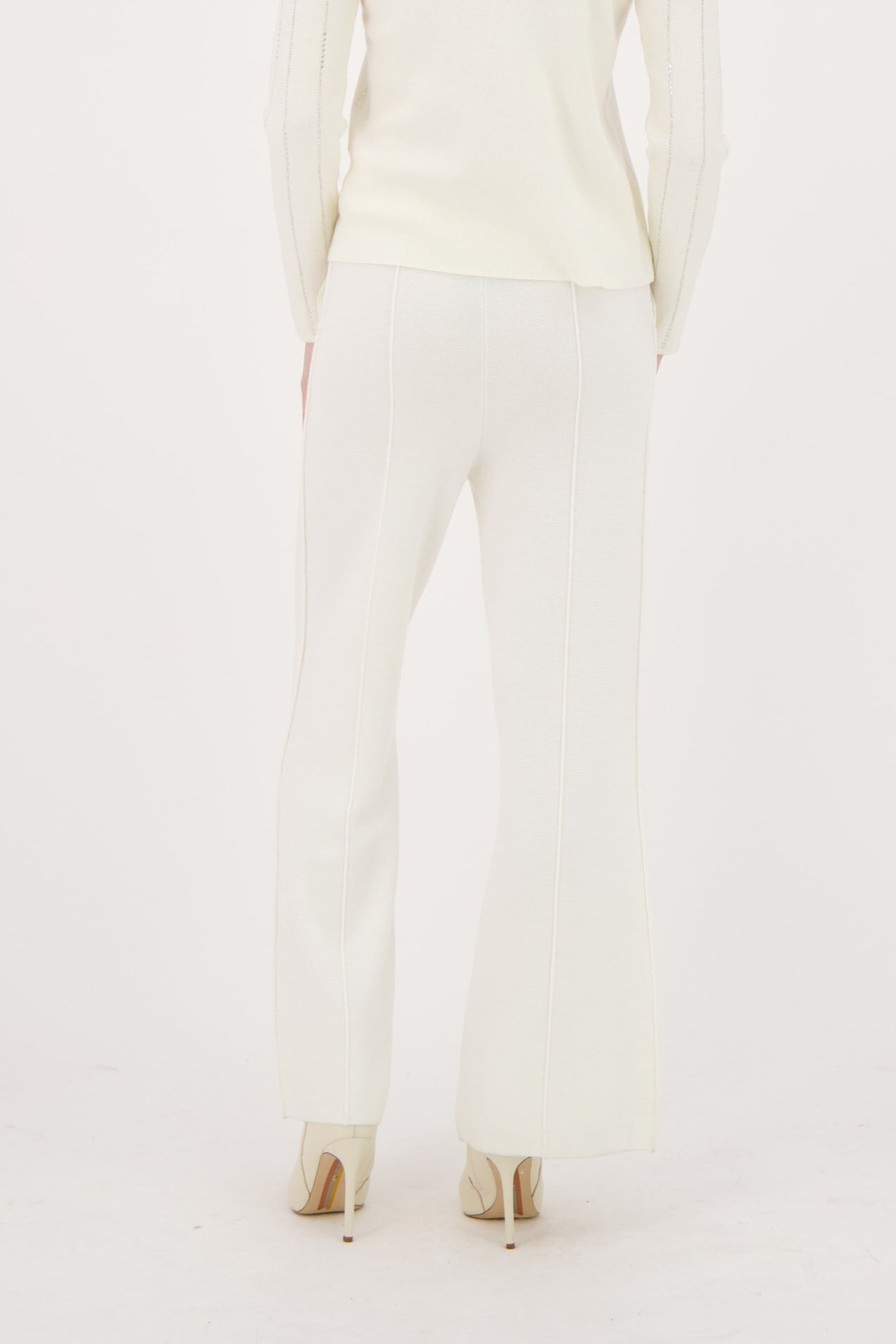 Woman wearing a white outfit on a plain background