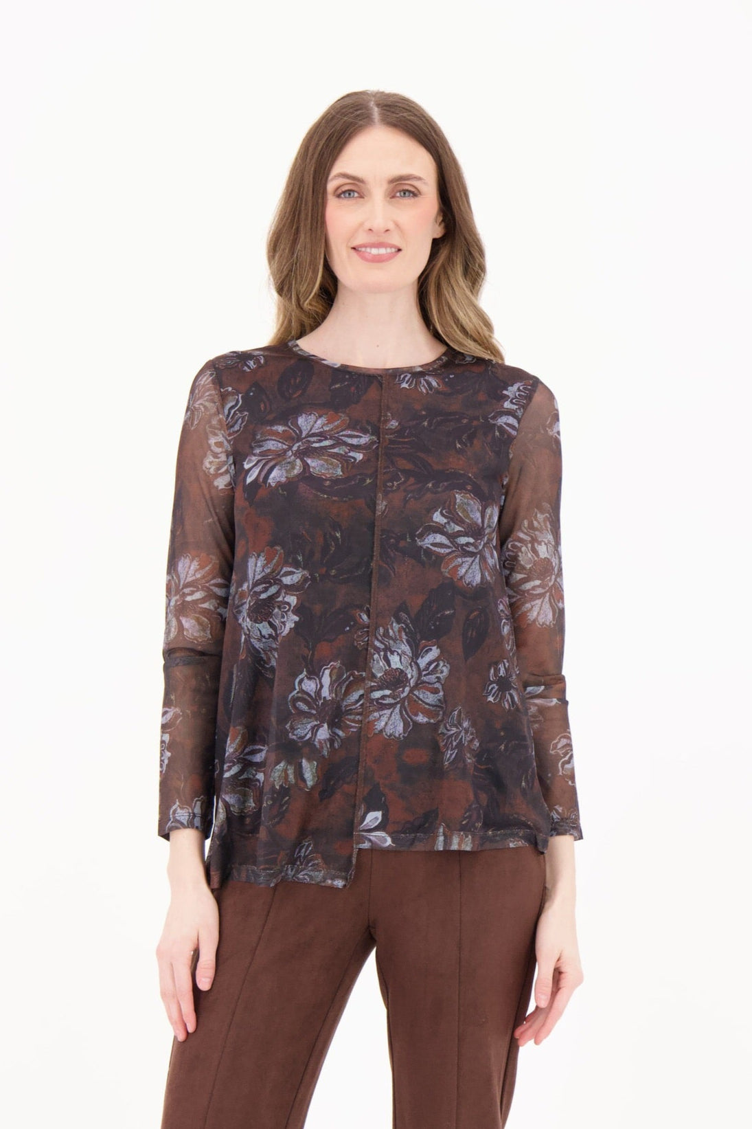 Woman wearing a floral top and brown pants on a white background