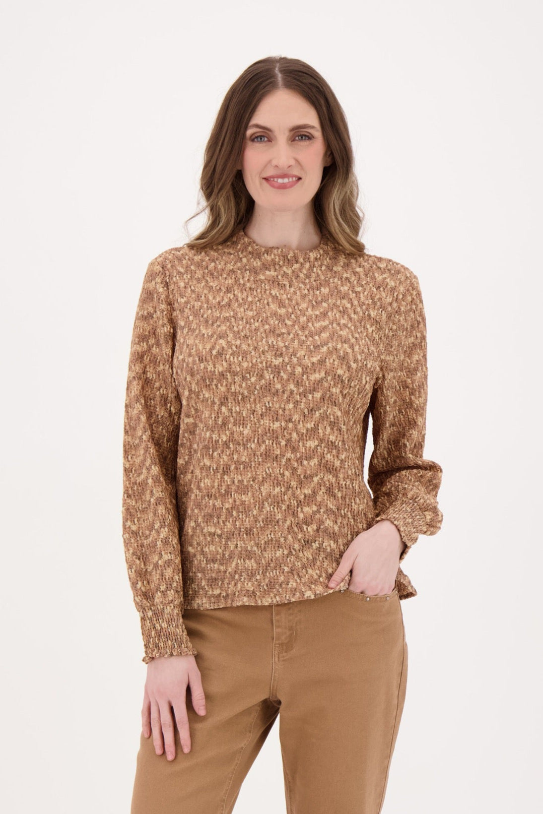 Woman wearing a brown patterned sweater and matching pants on a white background