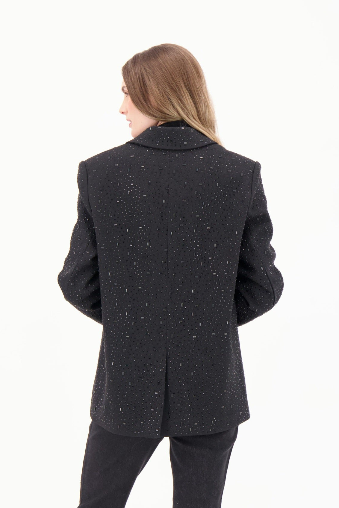 Person wearing a black textured coat on a white background