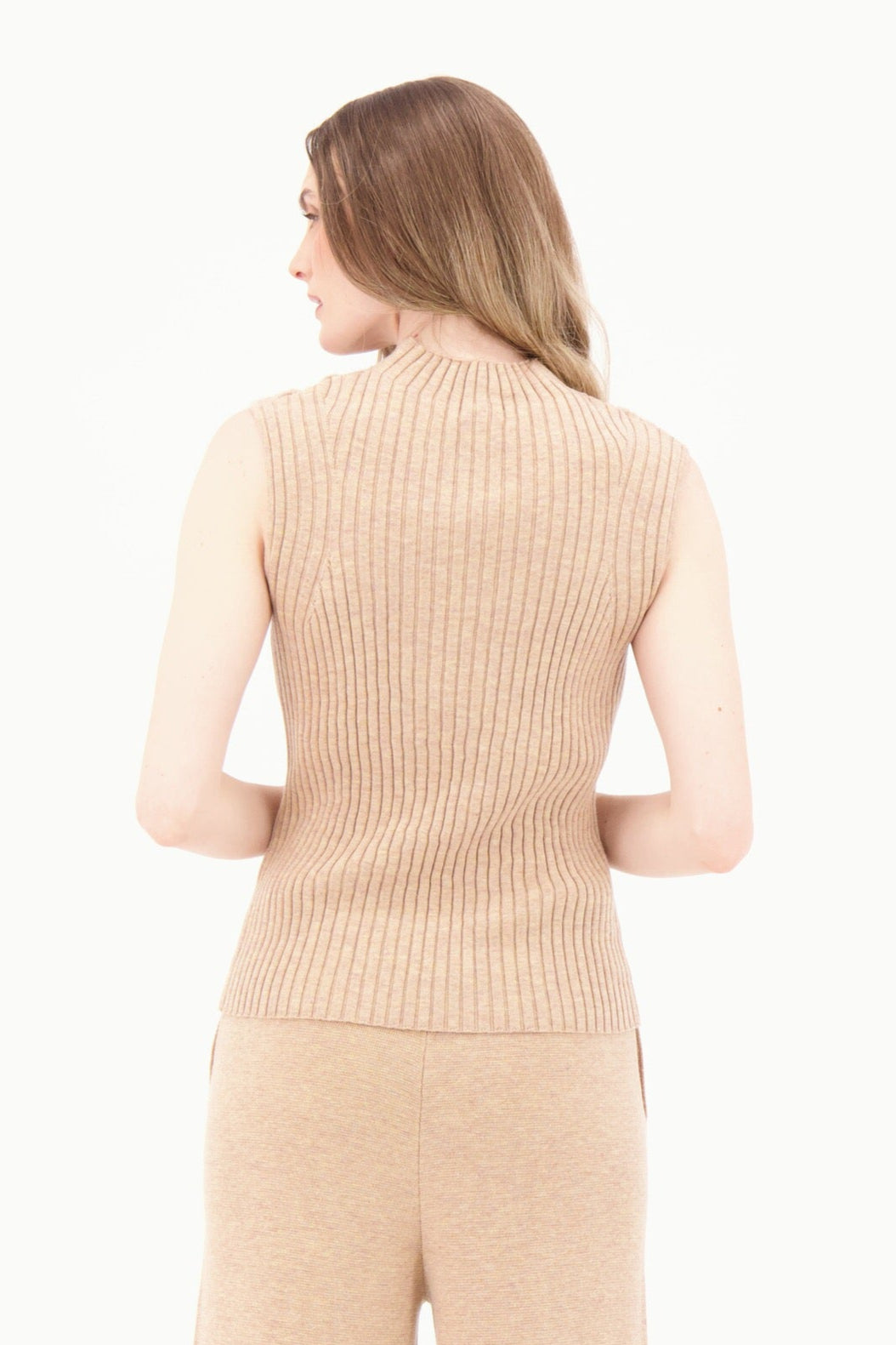Woman wearing a beige ribbed sleeveless top and wide-leg pants on a white background