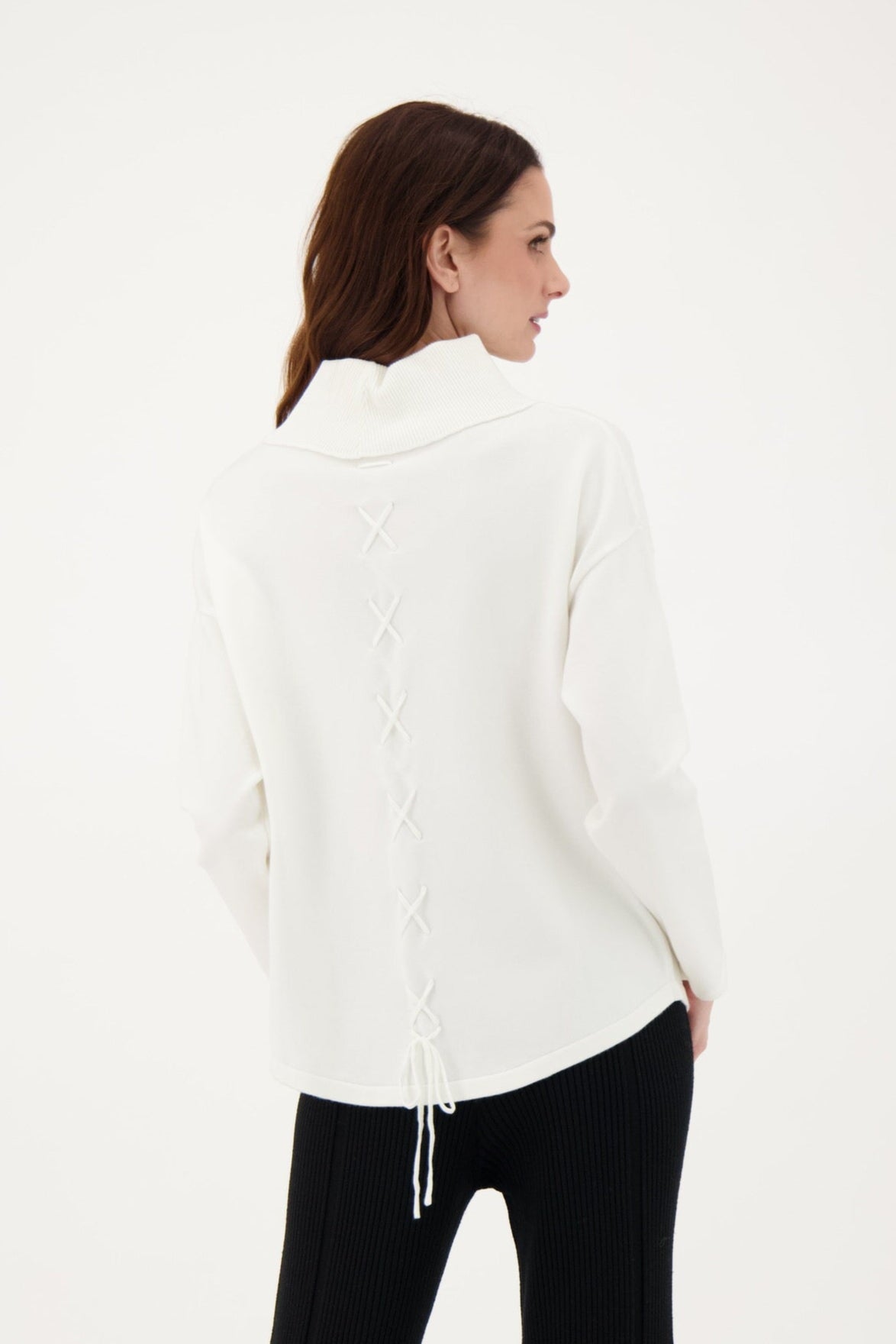 Woman wearing a white blouse and black pants on a white background