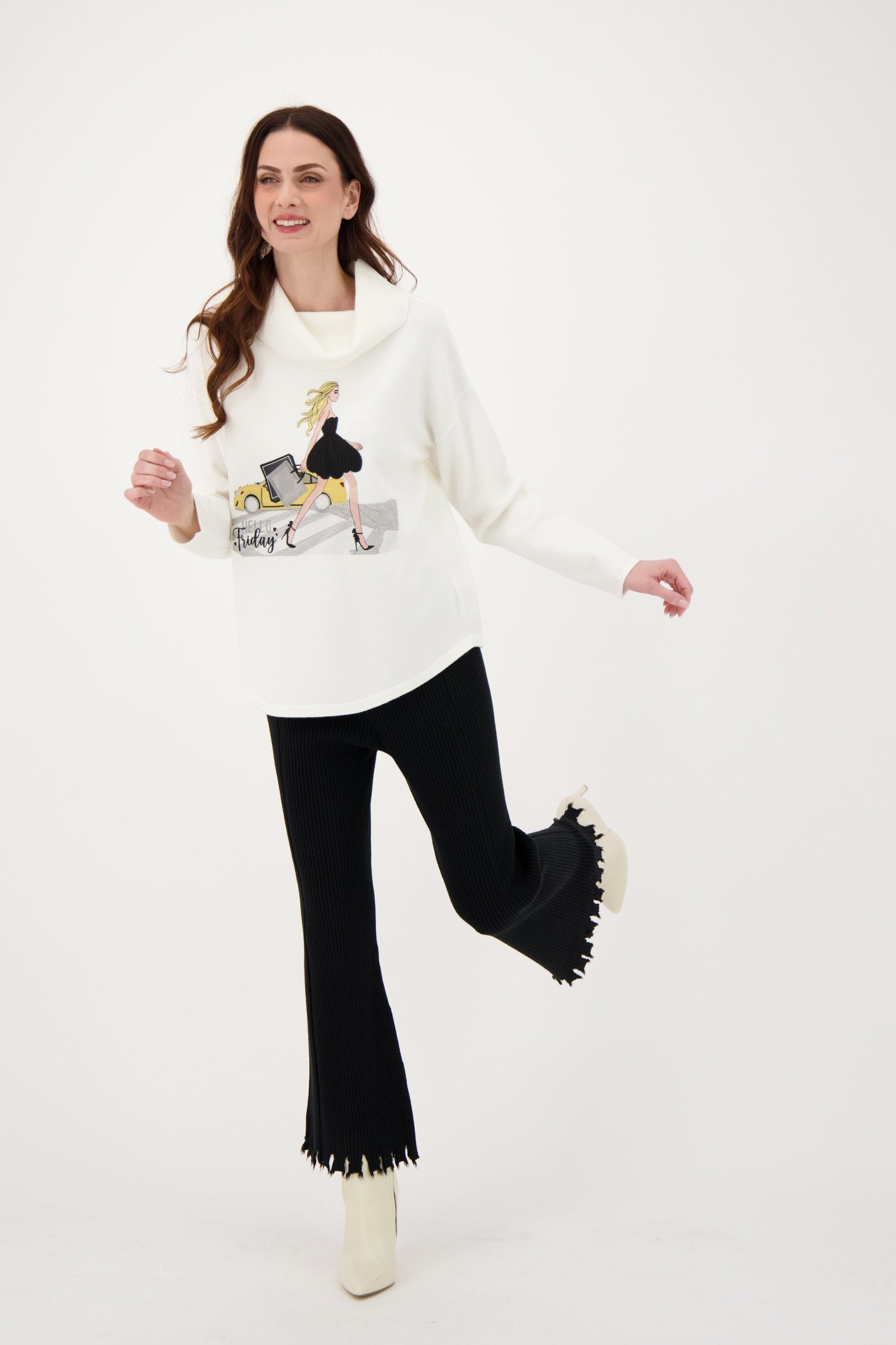 Woman wearing a white sweater with fringe details, black pants, and white boots on a white background
