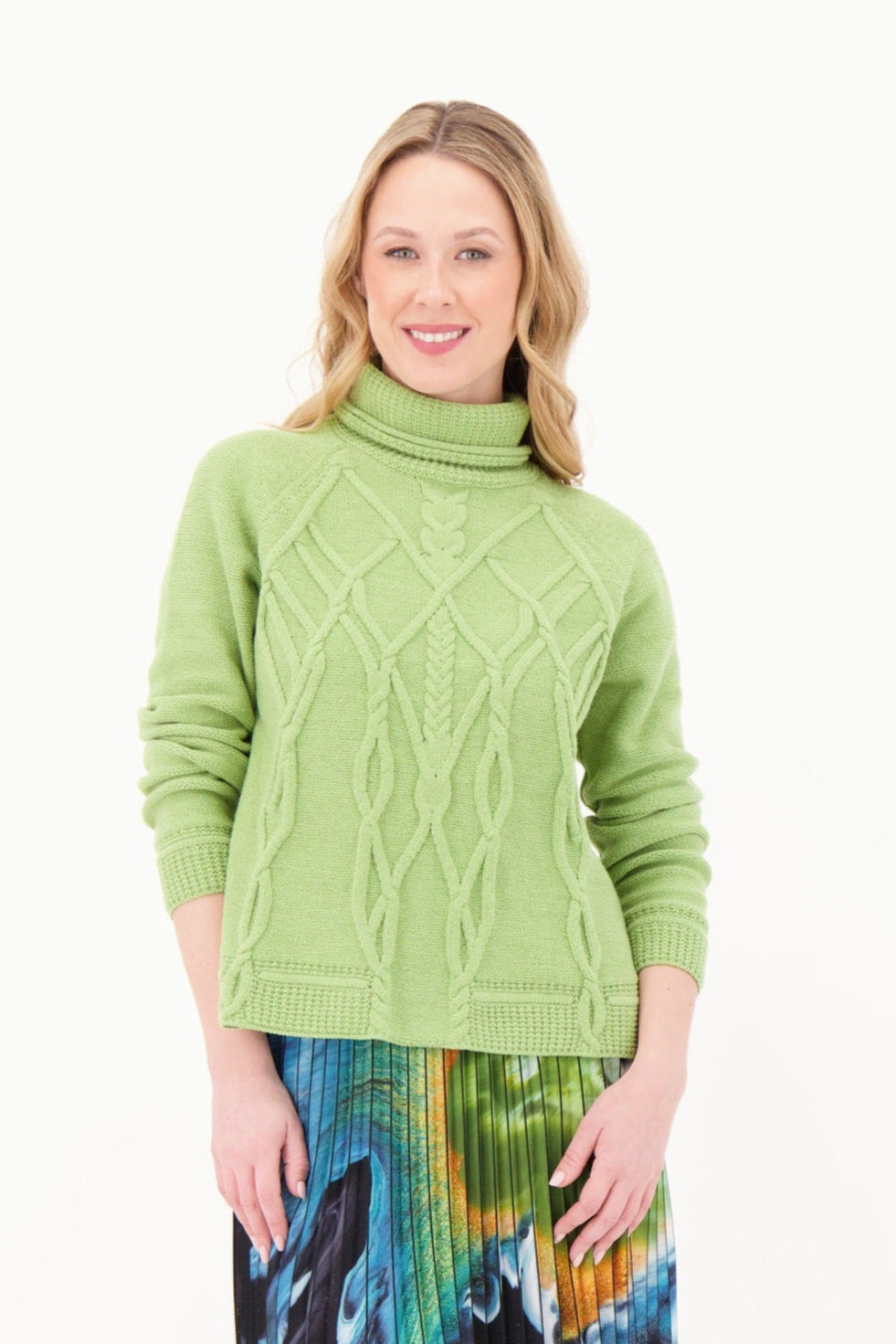 Woman wearing a green cable knit sweater on a white background
