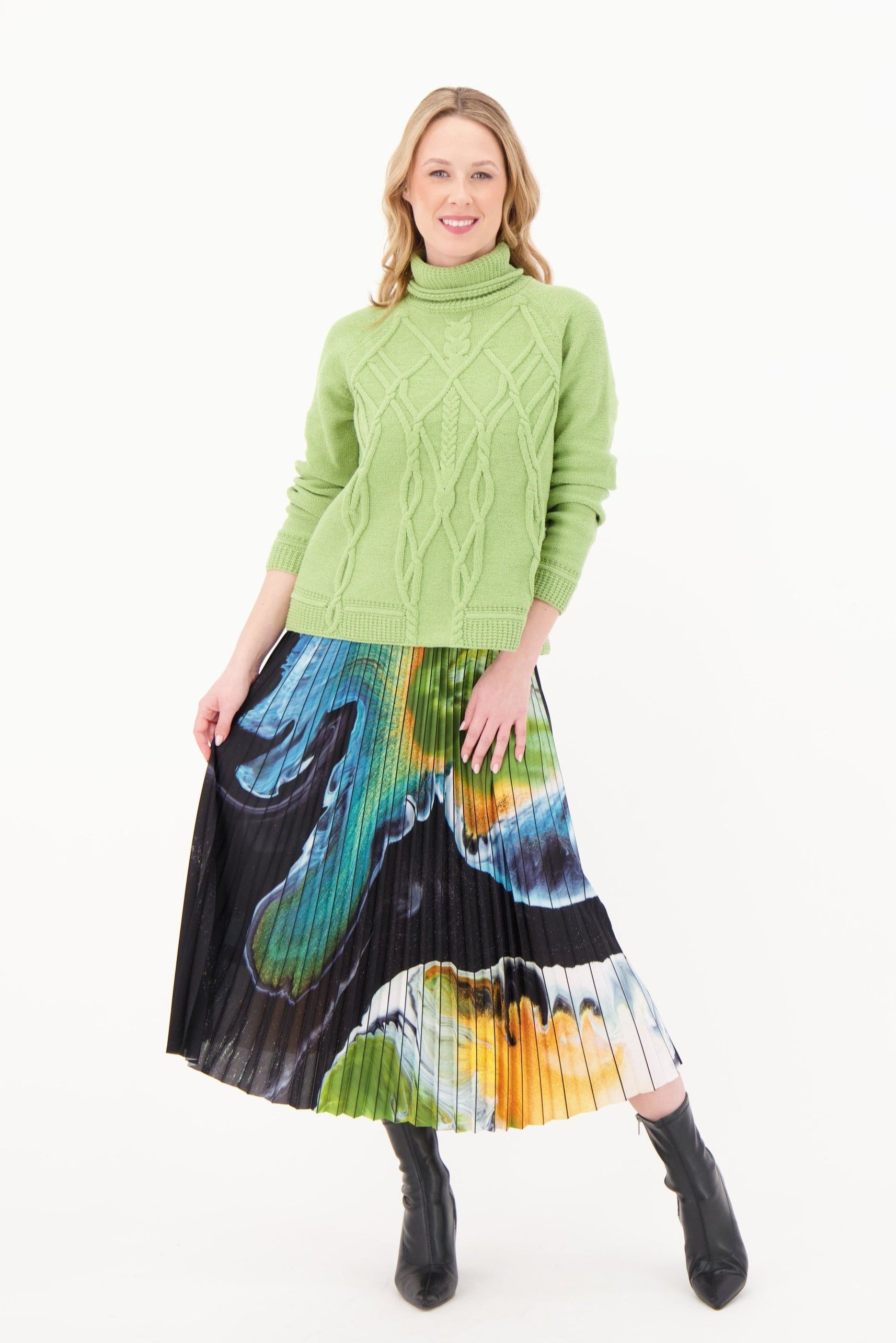 Woman wearing a green sweater and colorful skirt on a white background