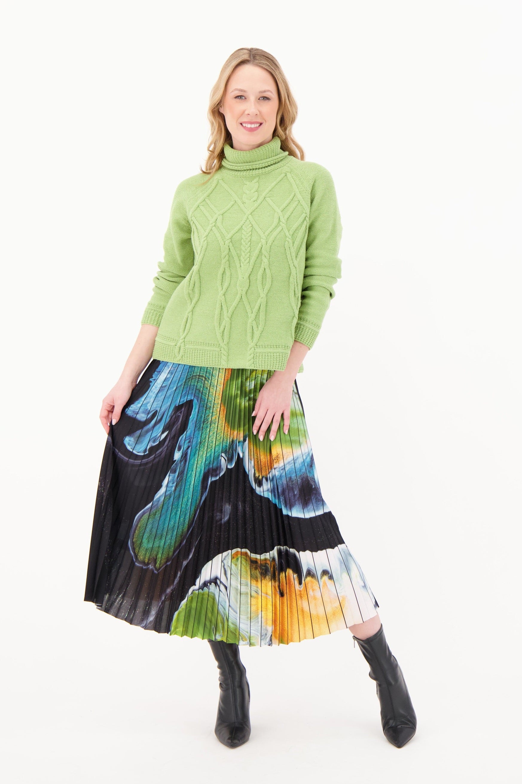 Woman wearing a green sweater and colorful skirt on a white background