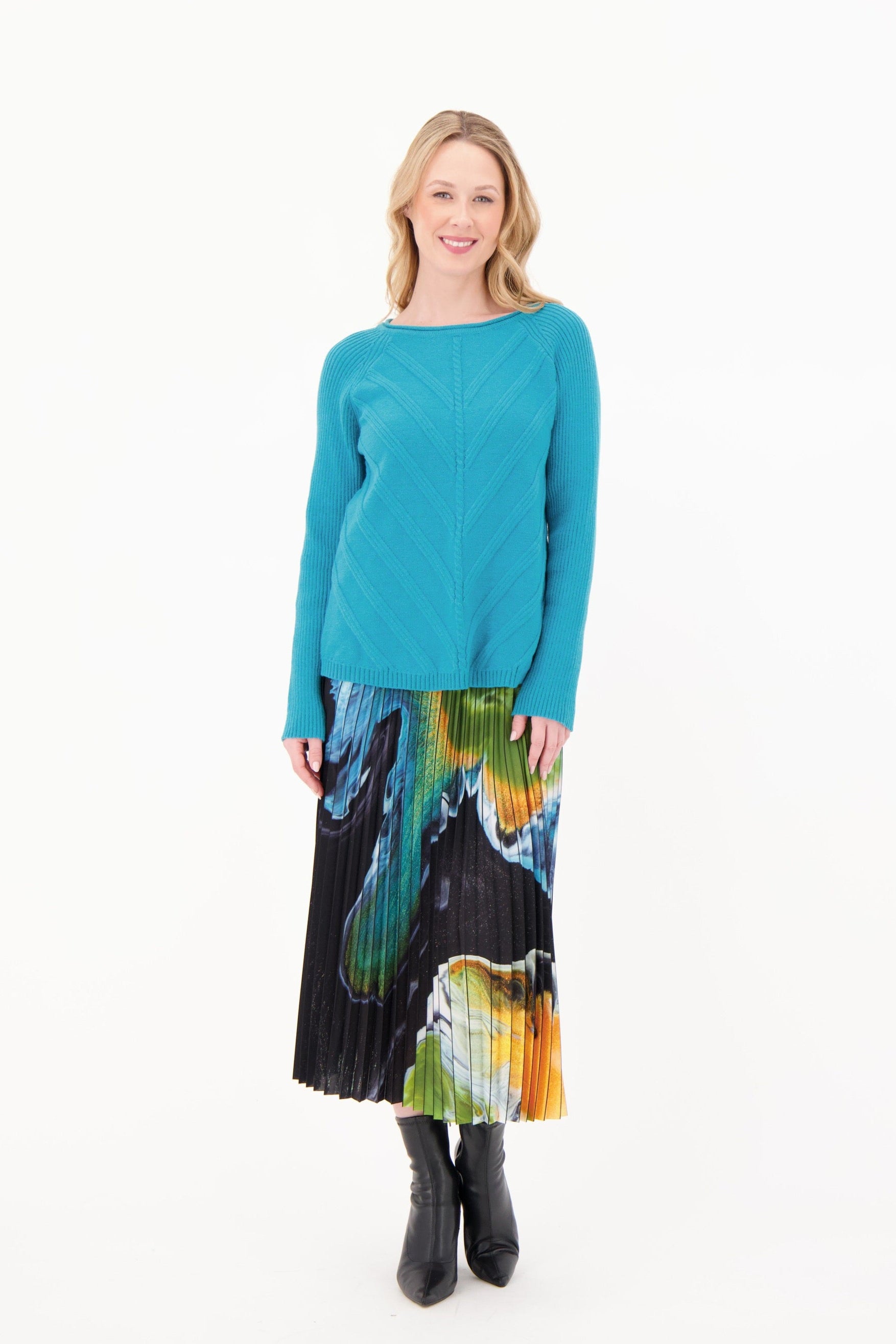 Woman wearing a teal sweater and colorful skirt on a white background
